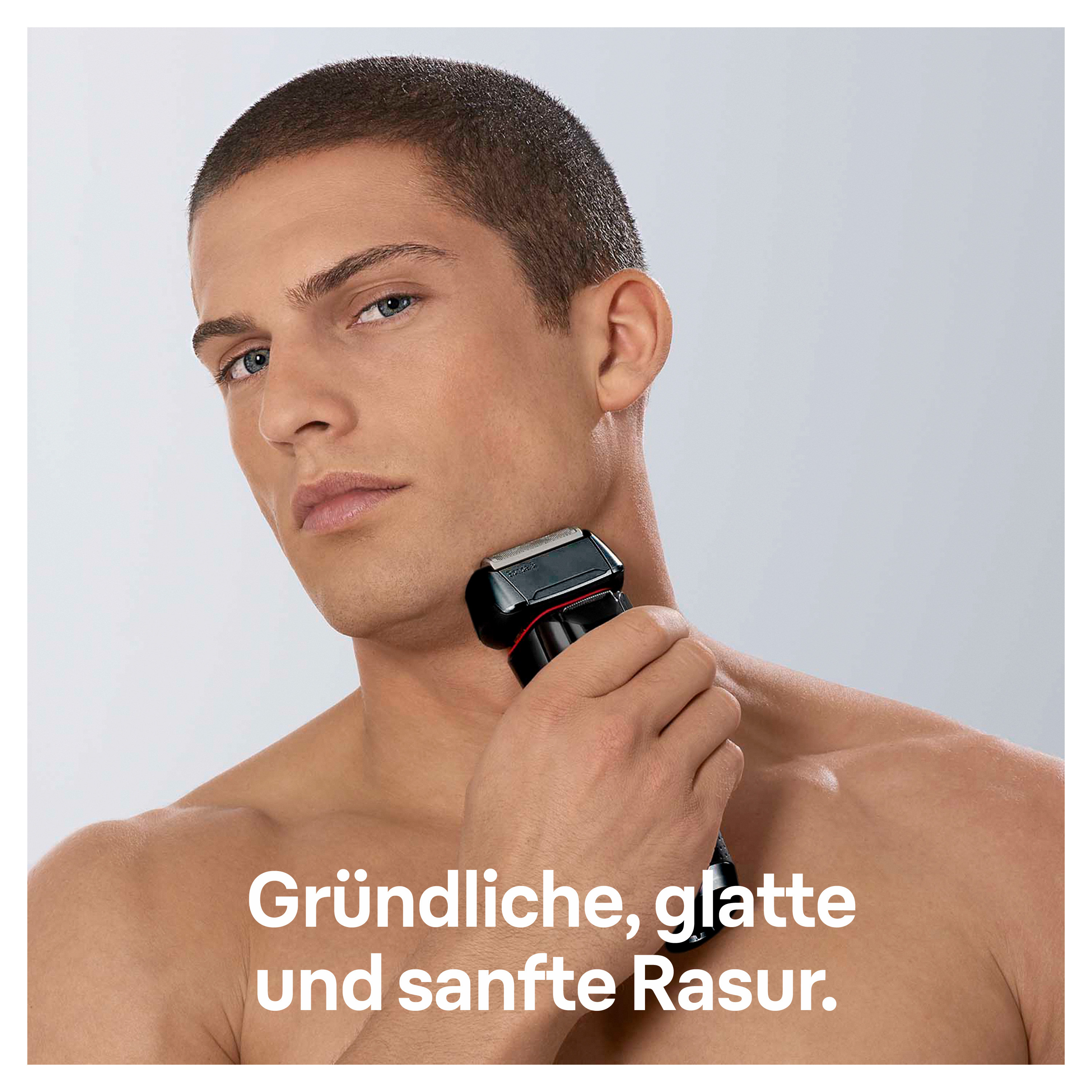 Un homme se rase le cou avec un rasoir électrique. Il a les cheveux courts bruns et la peau claire. Le fond est gris clair.