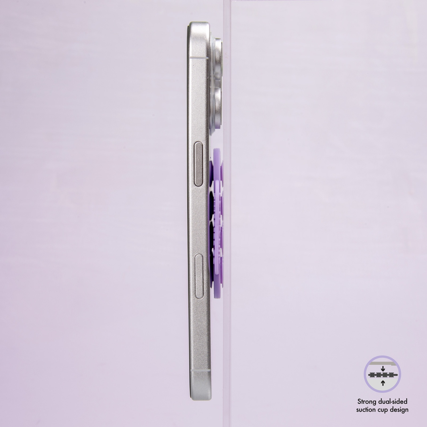 Telefono argentato con accessorio viola, su sfondo lilla chiaro. Design a ventosa visibile.