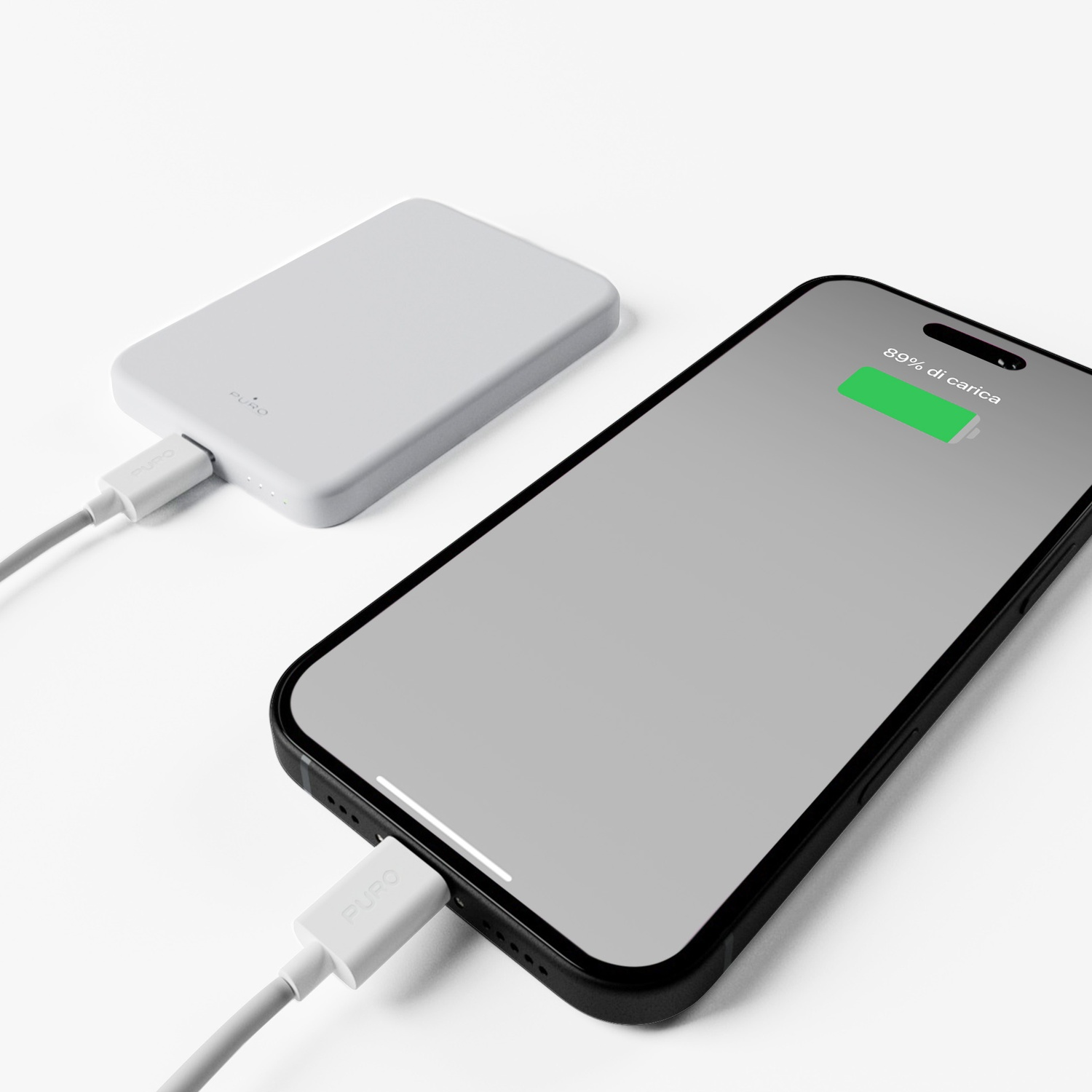 Un power bank bianco e uno smartphone nero, entrambi collegati tramite cavo. Il telefono mostra l'89% di carica.