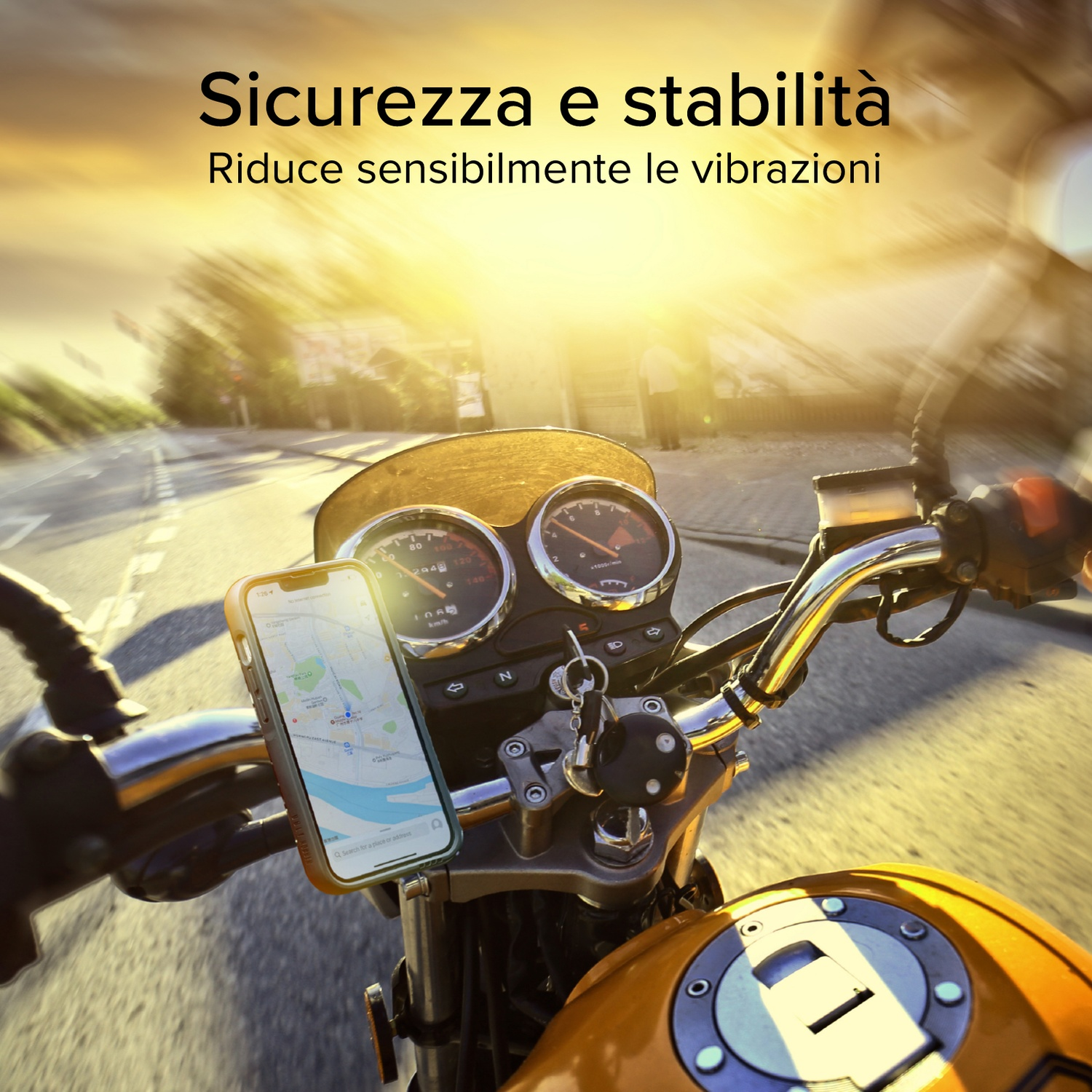 Cruscotto moto con telefono che mostra una mappa. Il sole splende luminoso. Strada e alberi visibili sullo sfondo.