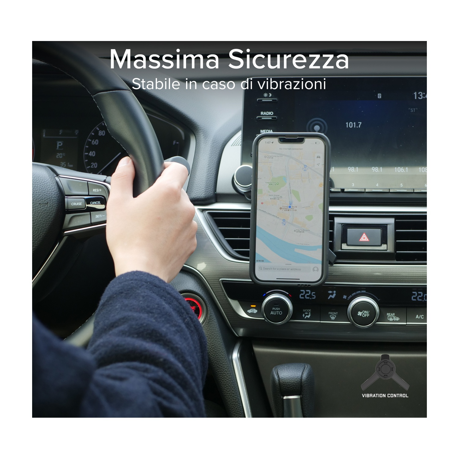 Mano sul volante. Telefono con mappa montato sul cruscotto. L'interno dell'auto è visibile.