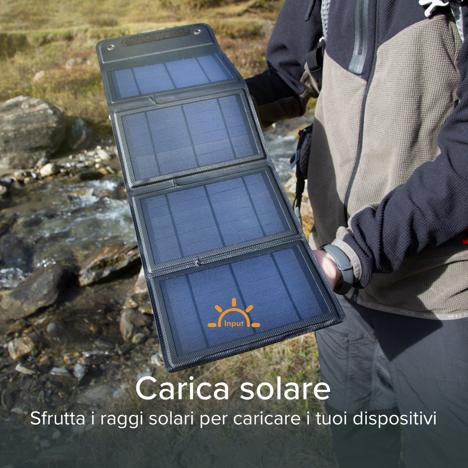 Persona che tiene in mano un pannello solare nero con celle blu, all'aperto. Lo sfondo mostra un ruscello e il fogliame.