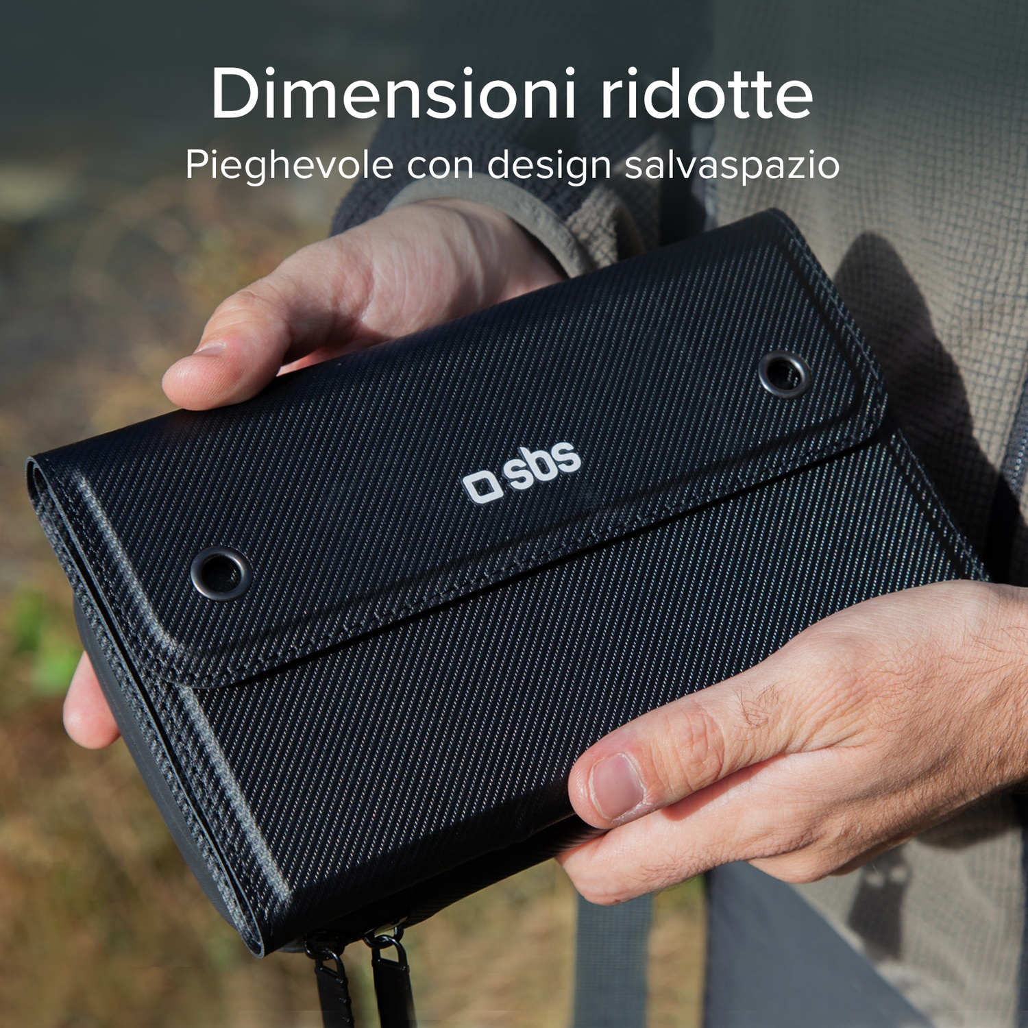 Persona tiene in mano un portafoglio nero e compatto. Il portafoglio ha un logo del marchio 'sbs'. Lo sfondo è sfocato, con il testo 'Dimensioni ridotte'.