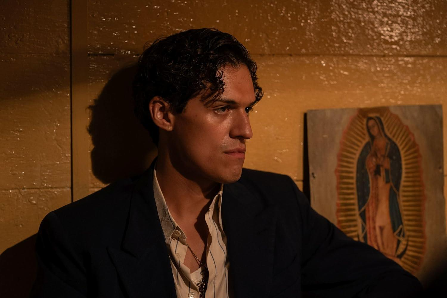 Ein Mann mit dunklem Haar blickt nach rechts, trägt ein Jackett und ein Hemd.