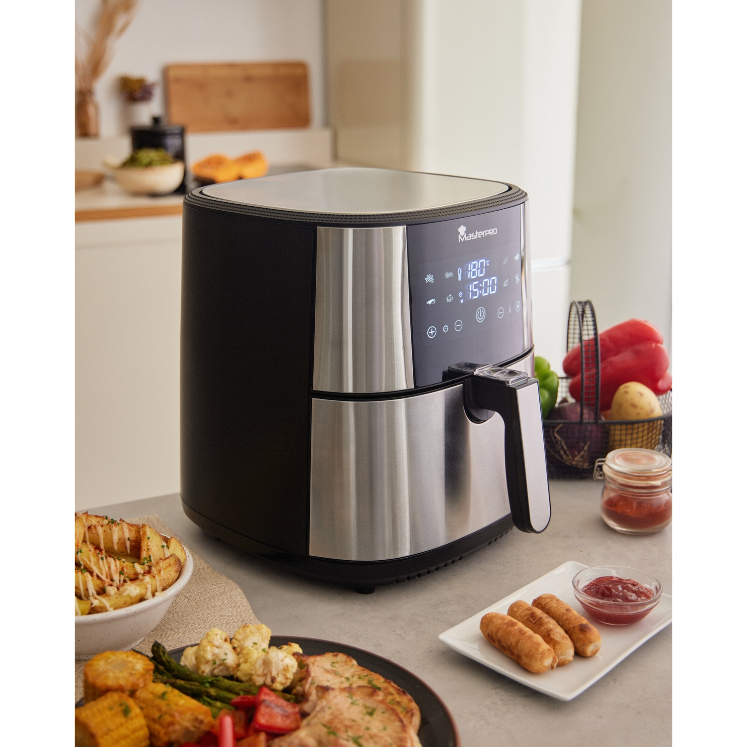 Friggitrice ad aria con display, vari cibi come mais, salsicce, patate, verdure. Ambiente cucina con verdure sullo sfondo.