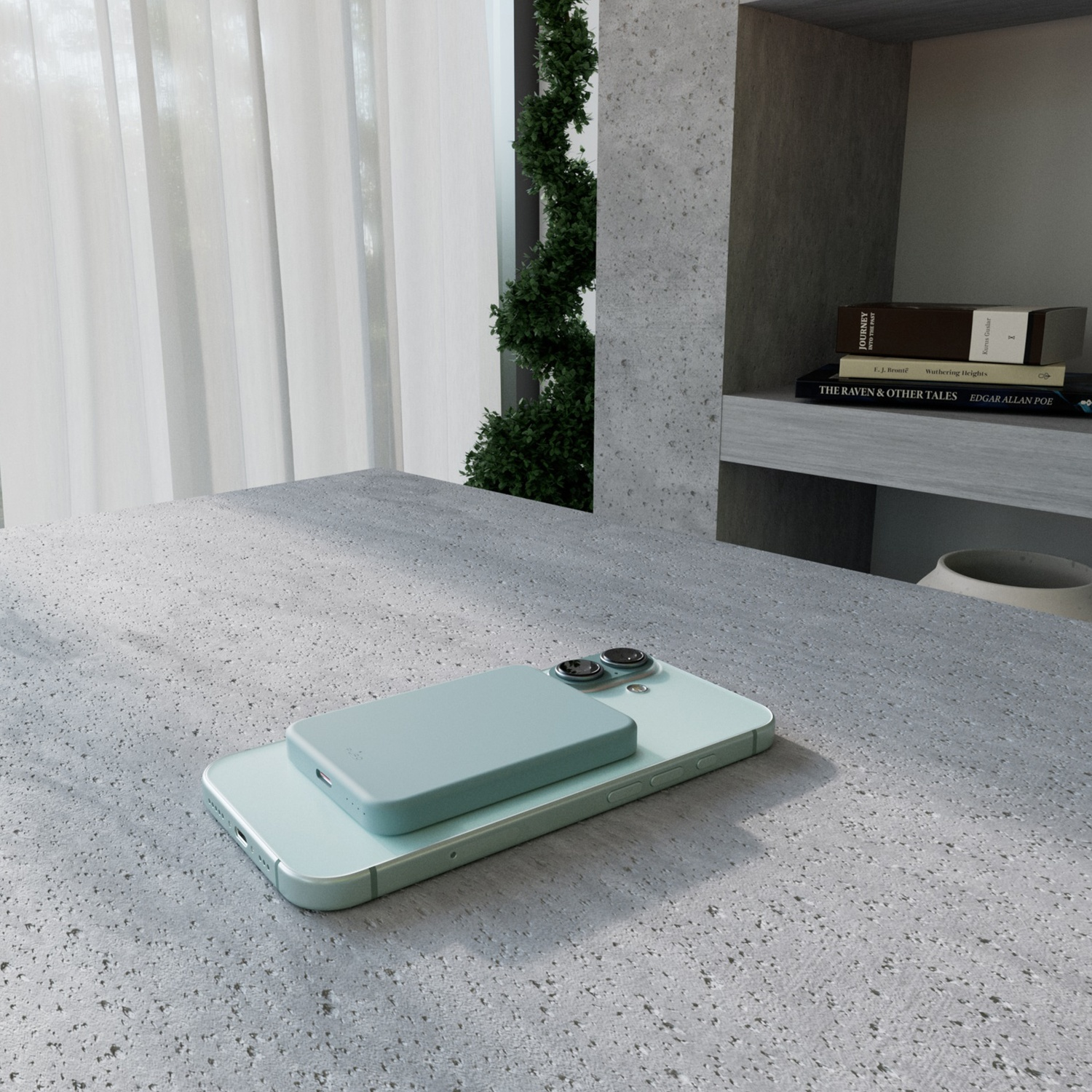 Un telefono verde chiaro con un caricabatterie abbinato su una superficie grigia strutturata. Libri e una pianta sullo sfondo.