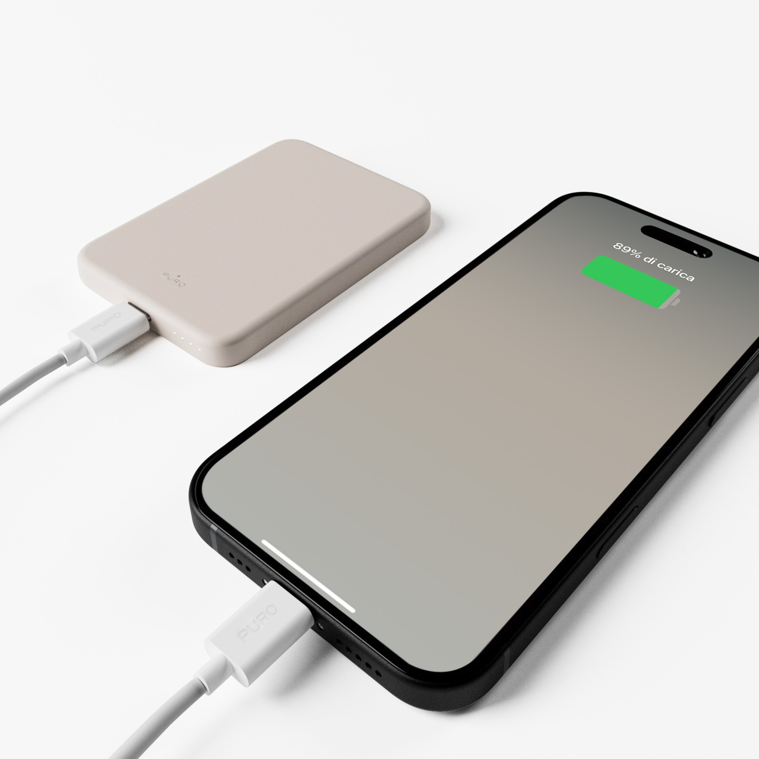 Un telefono si carica da un power bank. Il telefono mostra l'89% di carica. Entrambi collegati da cavi bianchi.