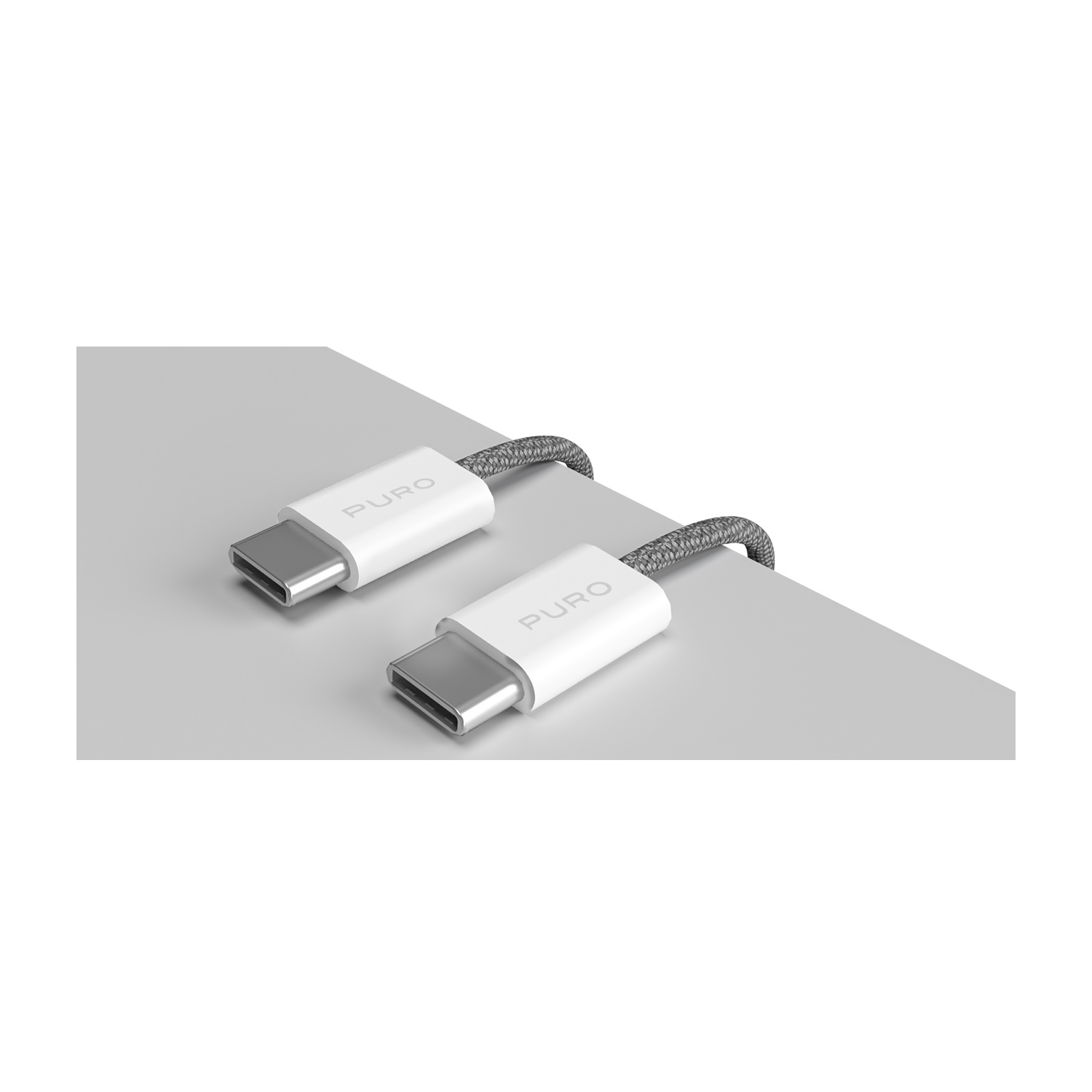 Due cavi USB-C bianchi con cordini intrecciati grigi. I connettori sono etichettati 'PURO' e poggiano su una superficie grigio chiaro.