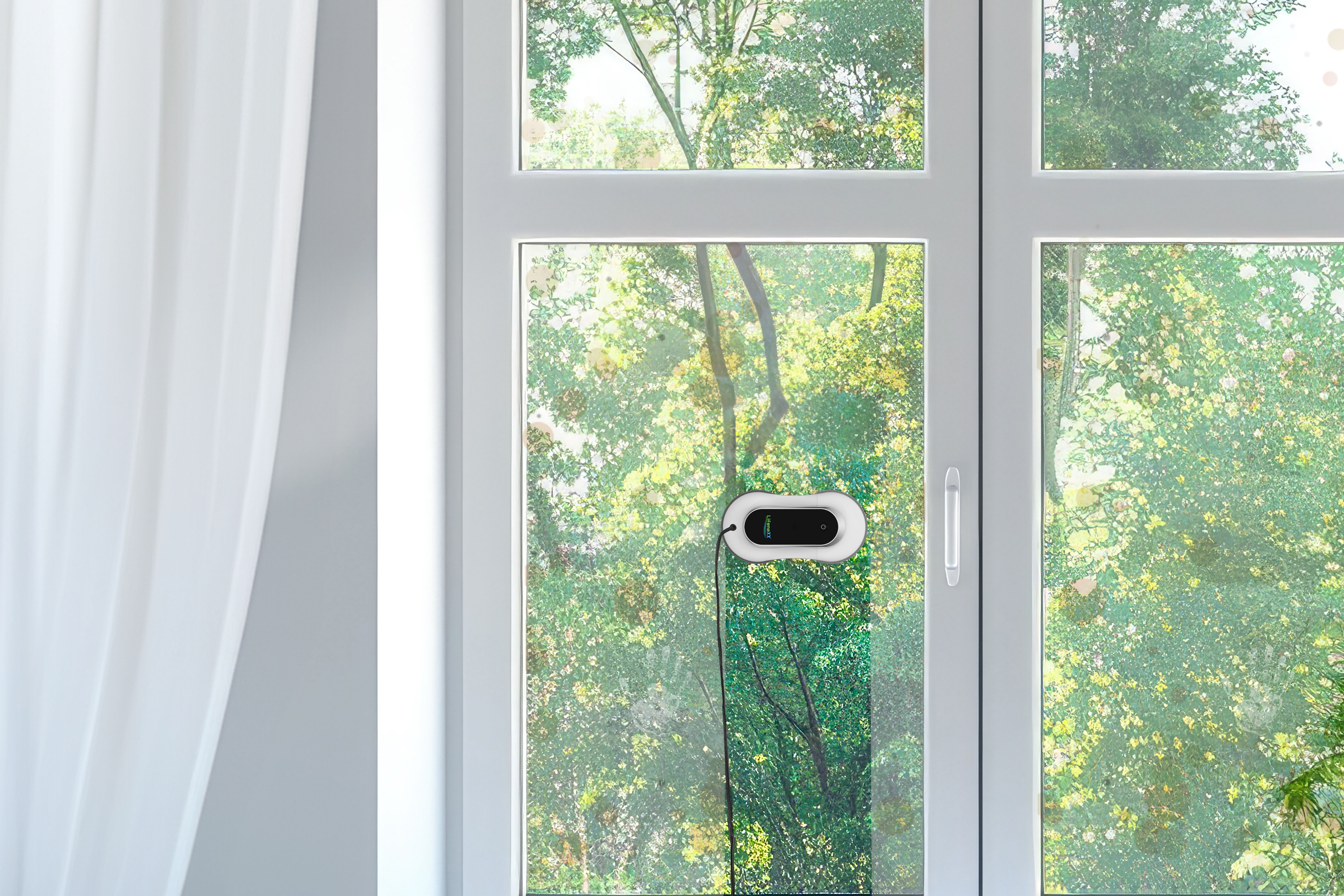 Okno z robotem czyszczącym. Na zewnątrz widoczne zielone liście. Biała zasłona po lewej.