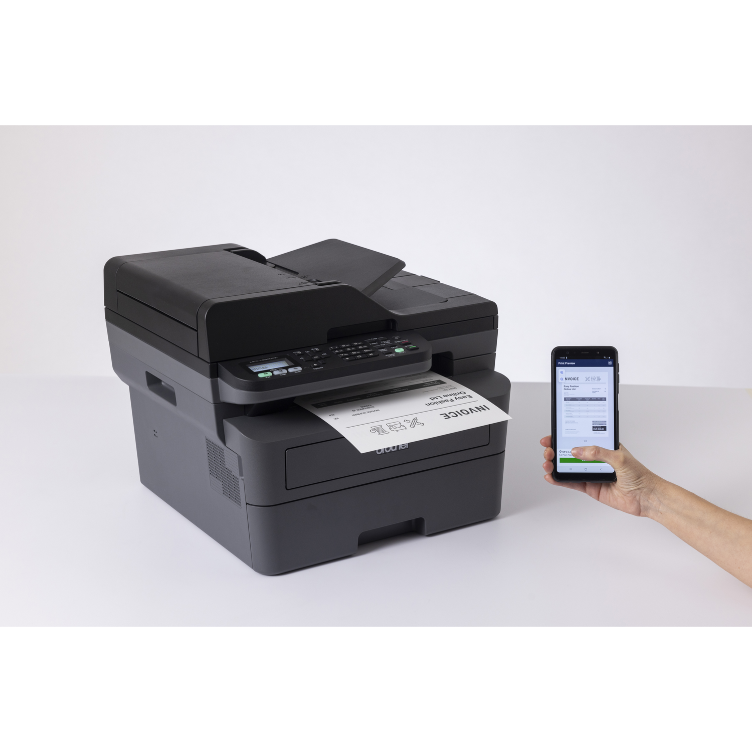 Black printer printing an invoice. A phone displays the invoice, held by a hand. White background.