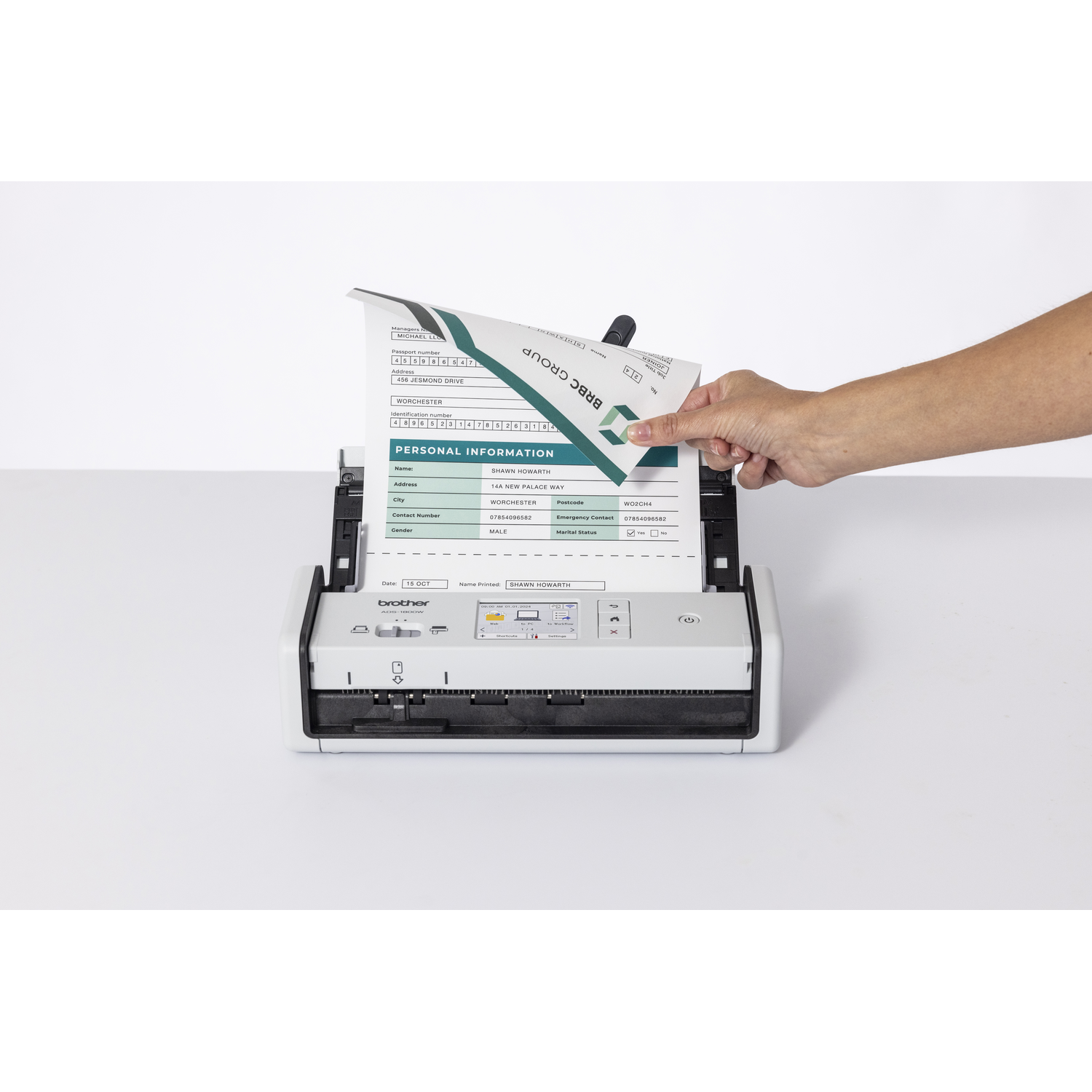 Een hand steekt een document in een scanner. Het document toont persoonlijke informatie. Een Brother-scanner is zichtbaar.