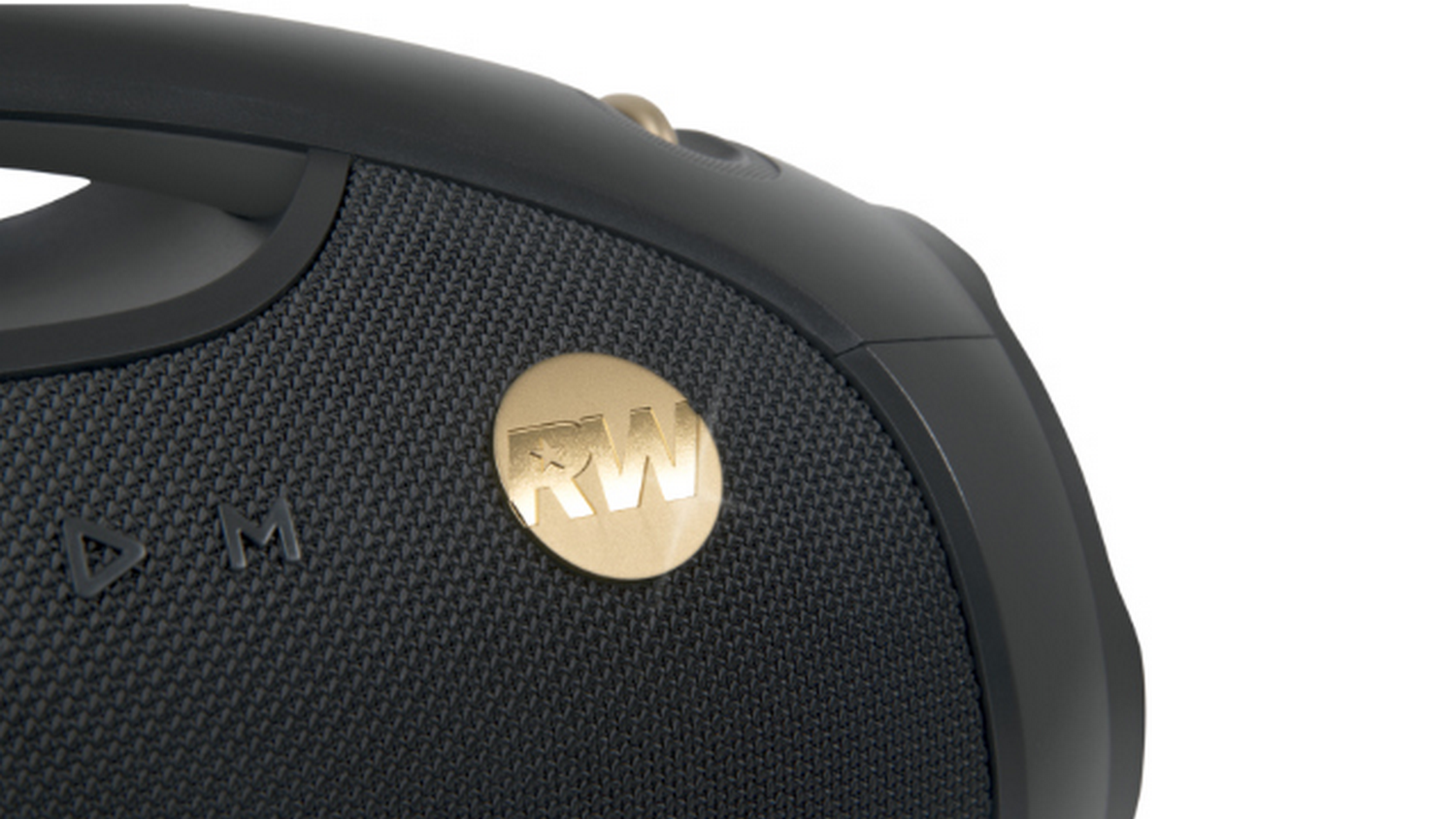 Primer plano de un altavoz negro con un emblema dorado que dice 'RW'. El altavoz tiene un asa y una superficie texturizada.
