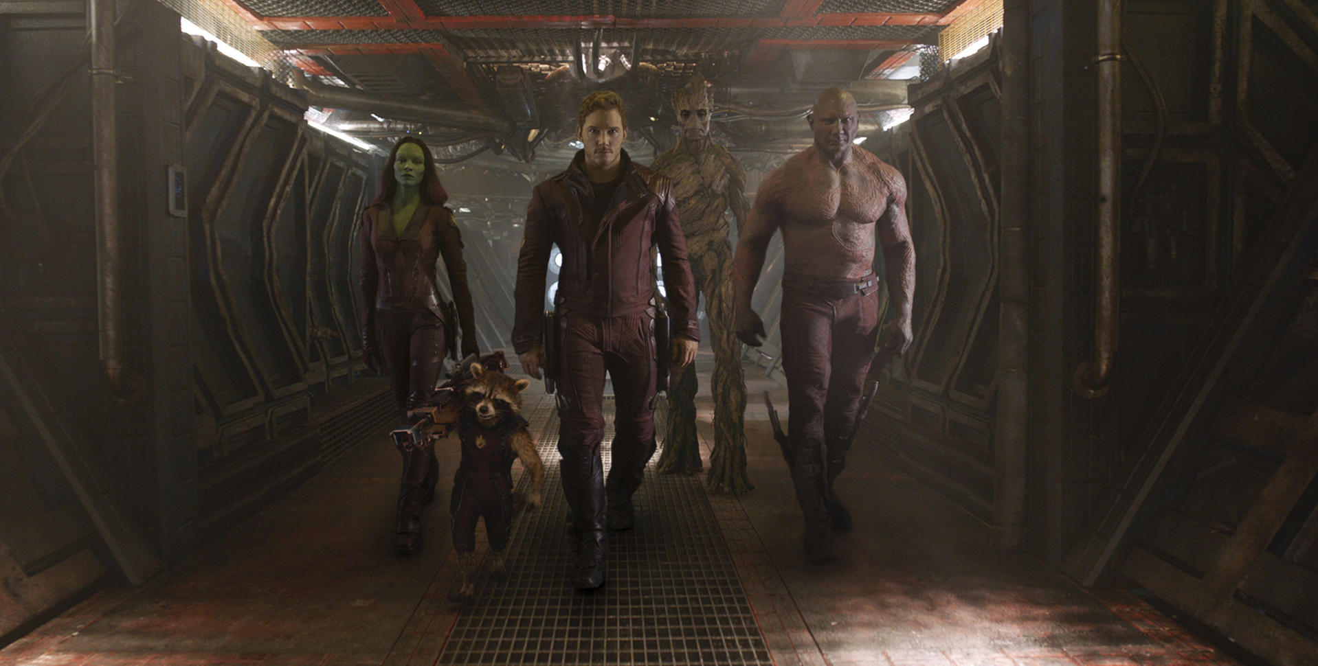 Die Guardians of the Galaxy gehen in einem Raumschiffkorridor. Zu den Charakteren gehören Star-Lord, Gamora, Drax, Rocket und Groot.