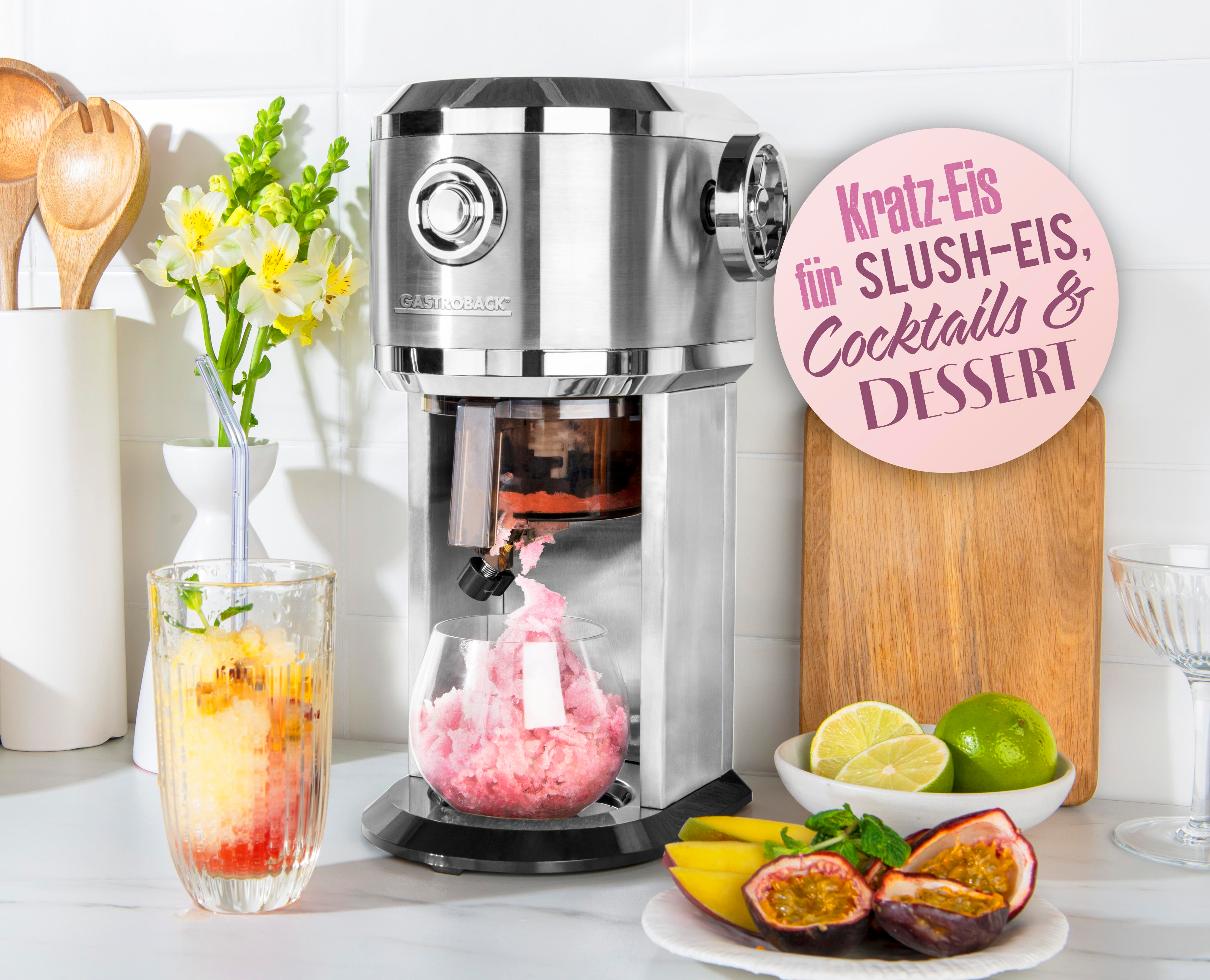 Eine silberne Slush-Maschine, die rosa Slushy herstellt. Ein Glas mit Slushy, Früchten und ein Schild sind in der Szene.
