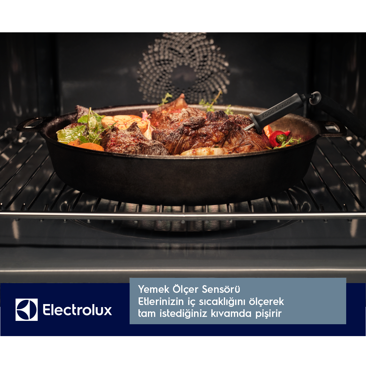 Fırında siyah bir tencerede kızarmış et ve sebzeler. Bir gıda sensörü takılı. Altta Electrolux logosu.