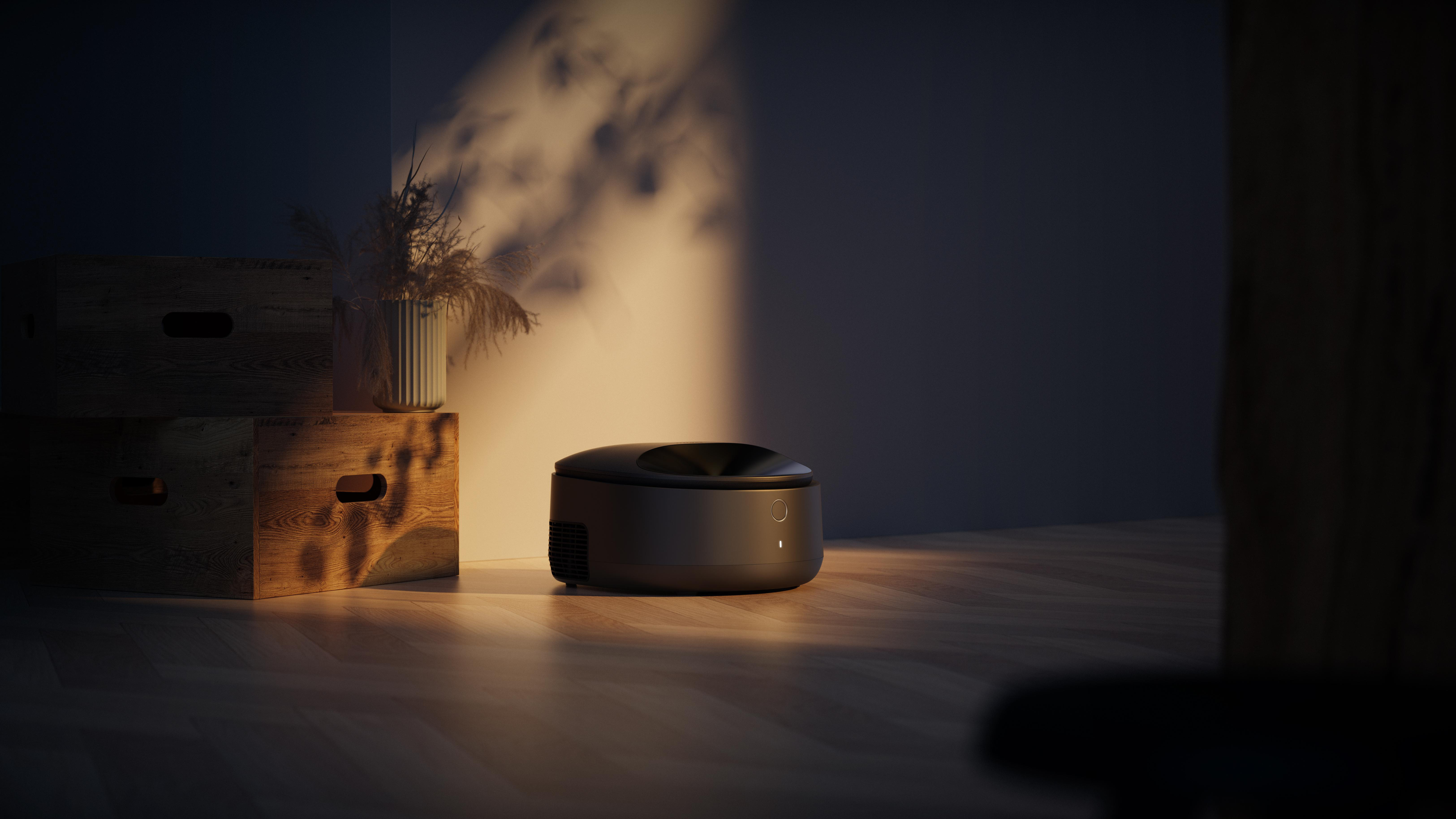 Ein schwarzer Roboter-Staubsauger auf einem Holzboden, neben Holzkisten und einer Vase mit Pflanzen. Schatten an der Wand.