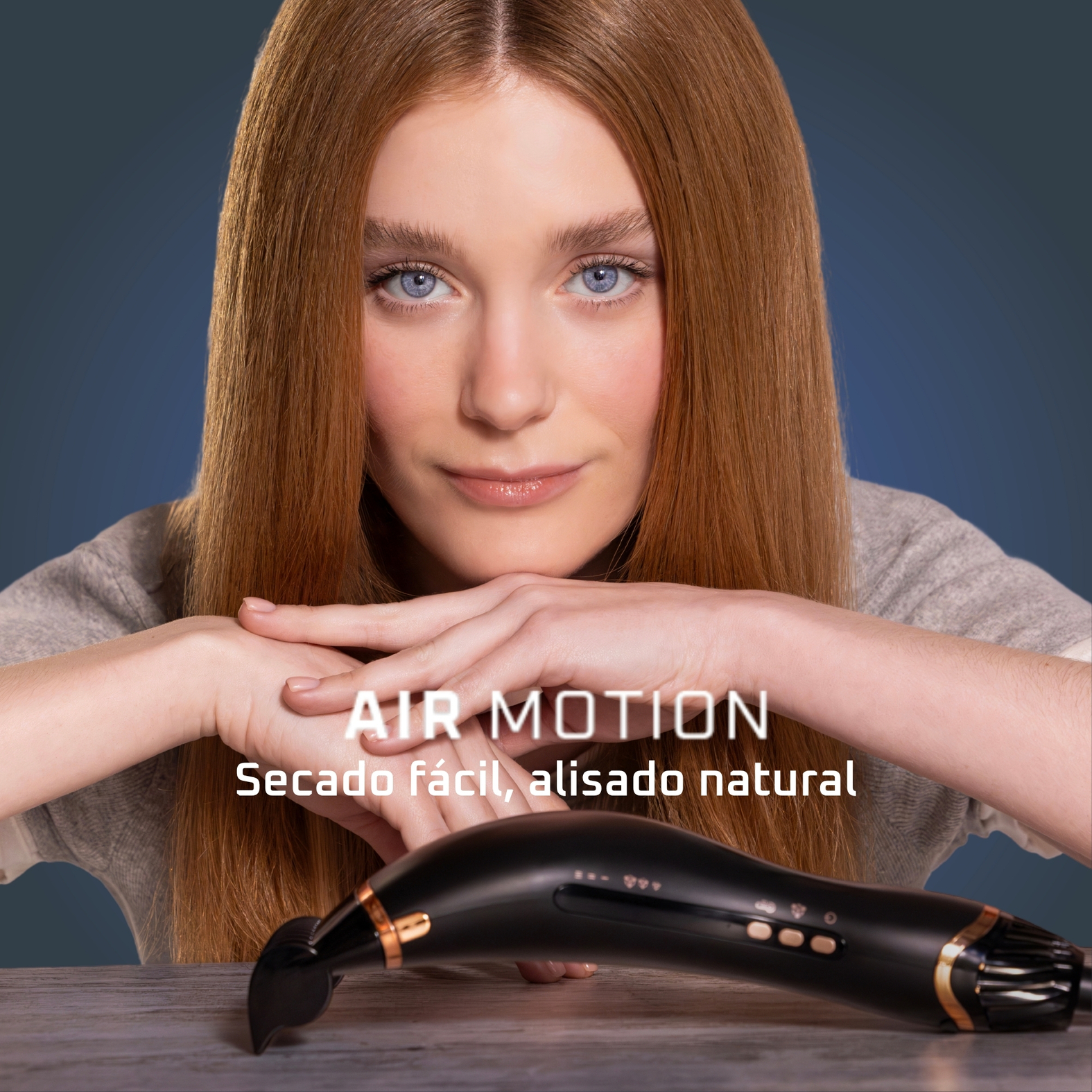 Una mujer pelirroja con ojos azules sostiene una herramienta de peinado. El texto dice: Air Motion, Secado fácil, alisado natural.