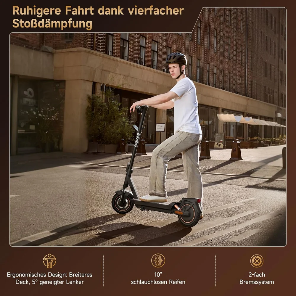 Un homme en casque roule sur une trottinette électrique dans la rue. Des bâtiments sont en arrière-plan. La trottinette est noire et grise.