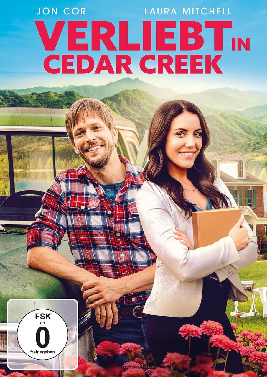 Kinoposter mit einem Mann und einer Frau, die lächeln. Titel: Verliebt in Cedar Creek. Berge und ein Haus sind im Hintergrund.