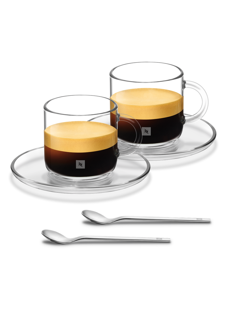 Zwei Espressotassen mit Untertassen und Löffeln. Espresso hat einen cremigen Schaum. Klare Glasbecher und Untertassen.