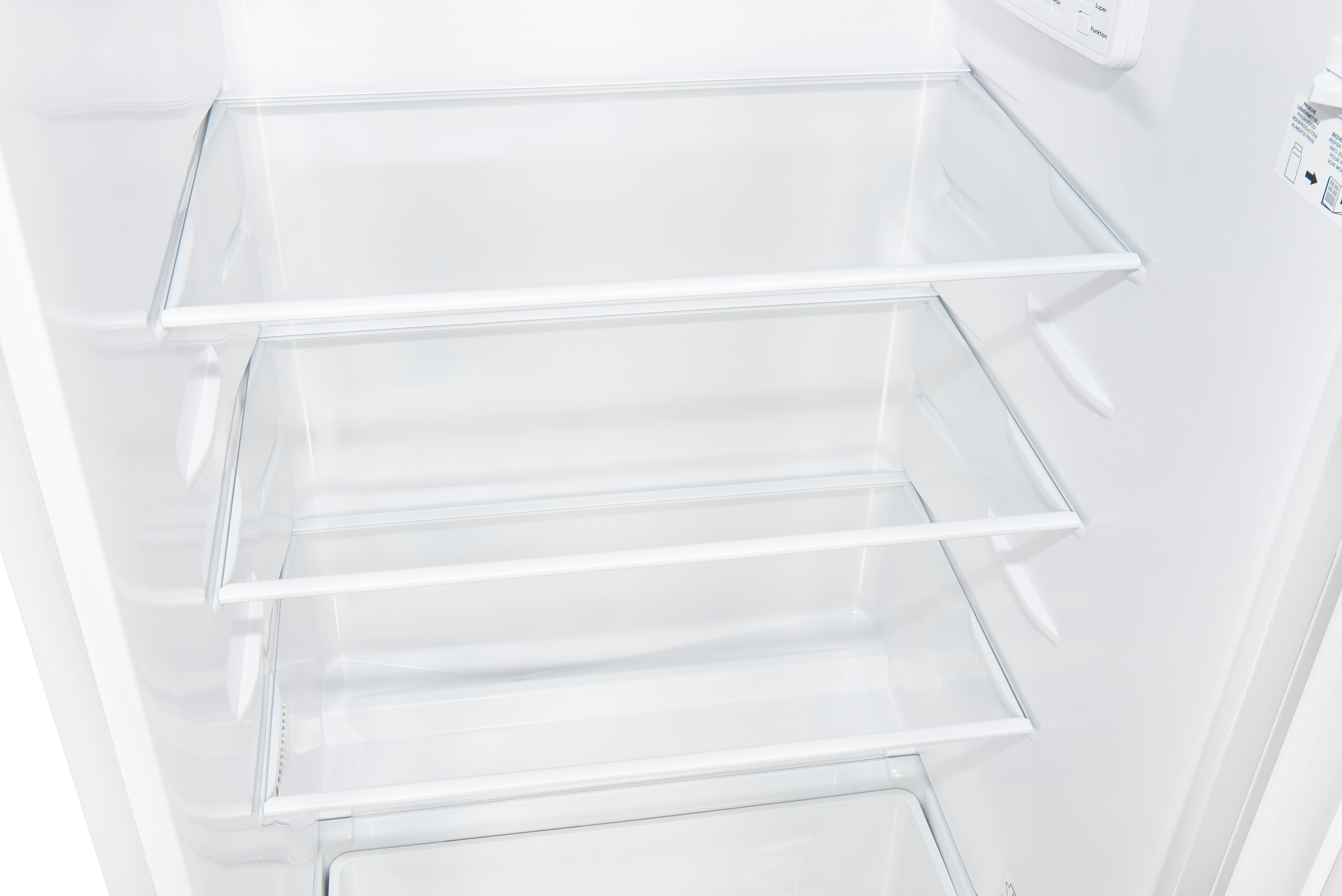 In einem weißen Kühlschrank. Sichtbar sind leere Regale, die Innenwände und ein Bedienfeld. Eine saubere, minimalistische Ästhetik.