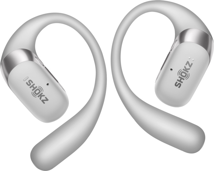Deux écouteurs à conduction osseuse Shokz blancs sont affichés. Ils ont un design incurvé qui contourne l'oreille.