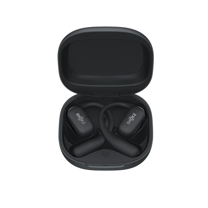 Auriculares Shokz negros en un estuche negro abierto. Los auriculares son de estilo de conducción ósea. El estuche está abierto.
