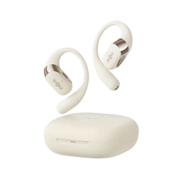 Auriculares y estuche de carga Shokz de color crema. Los auriculares son de tipo conducción ósea. El estuche es un rectángulo redondeado.