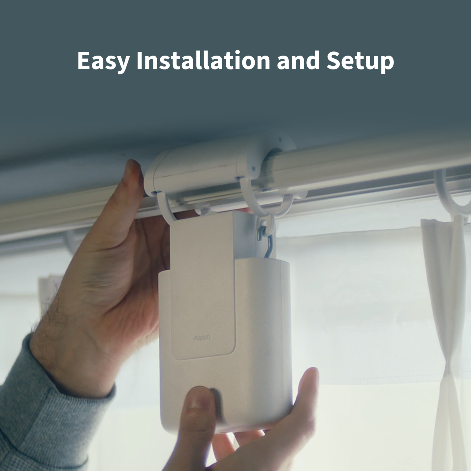 Hands installing a white device on a curtain rod. The device is labeled 'Aqara'. Background: curtains and a window.
