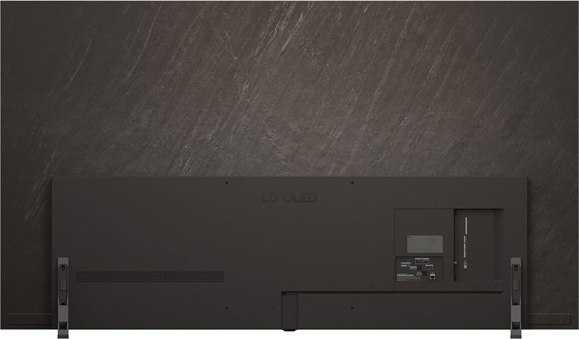 Vue arrière d'un téléviseur LG OLED gris foncé contre un mur gris texturé. Ports et nom du modèle visibles.