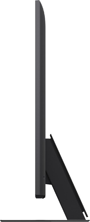 Vista laterale di una televisione nera e sottile. È su un supporto nero. Lo schermo è scuro.
