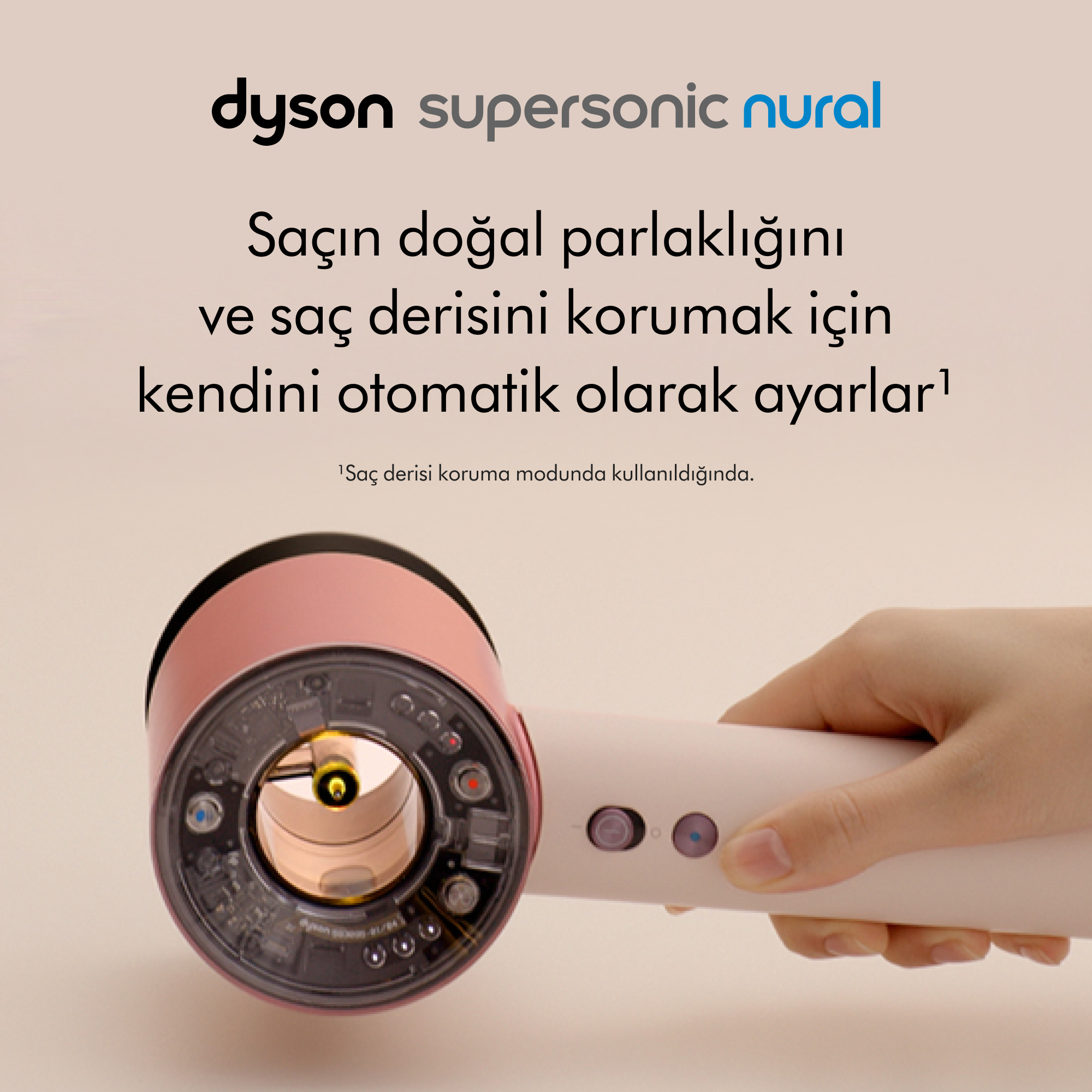 Bir Dyson Supersonic Nural saç kurutma makinesi tutuluyor. Pembe ve beyaz, Türkçe metinli.