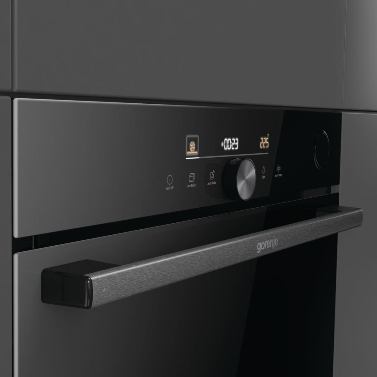 Sötétszürke Gorenje sütő előlapja. Digitális kijelzővel rendelkezik, időt és hőmérsékletet mutat. Fém fogantyú és gombok láthatók.