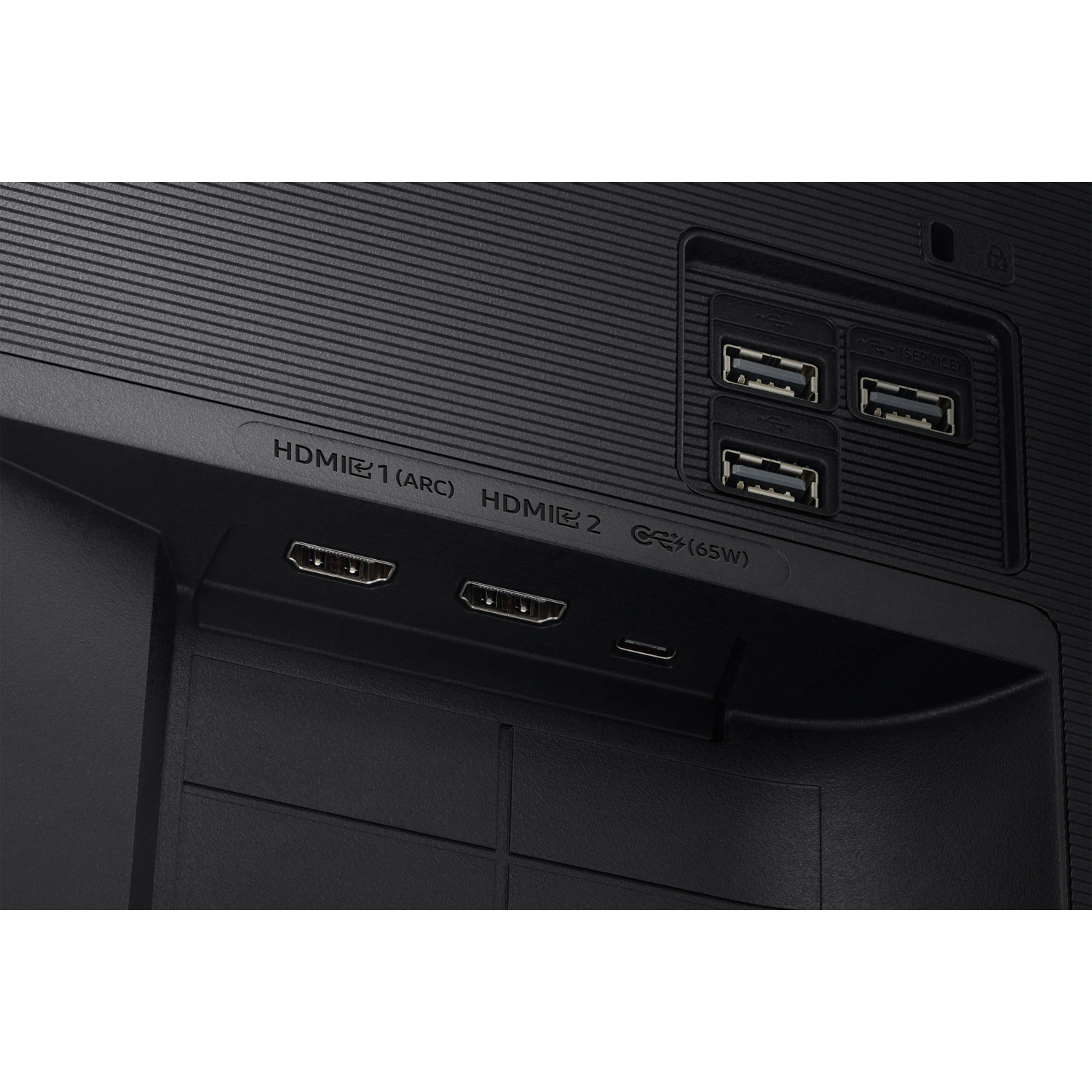 Close-up of a black monitor's back panel. HDMI, USB ports, and a power connector are visible. The panel has a textured surface.