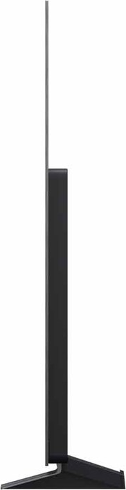 Una TV nera e moderna è in piedi. Lo schermo è sottile, con una cornice scura. Un supporto nero lo sostiene.