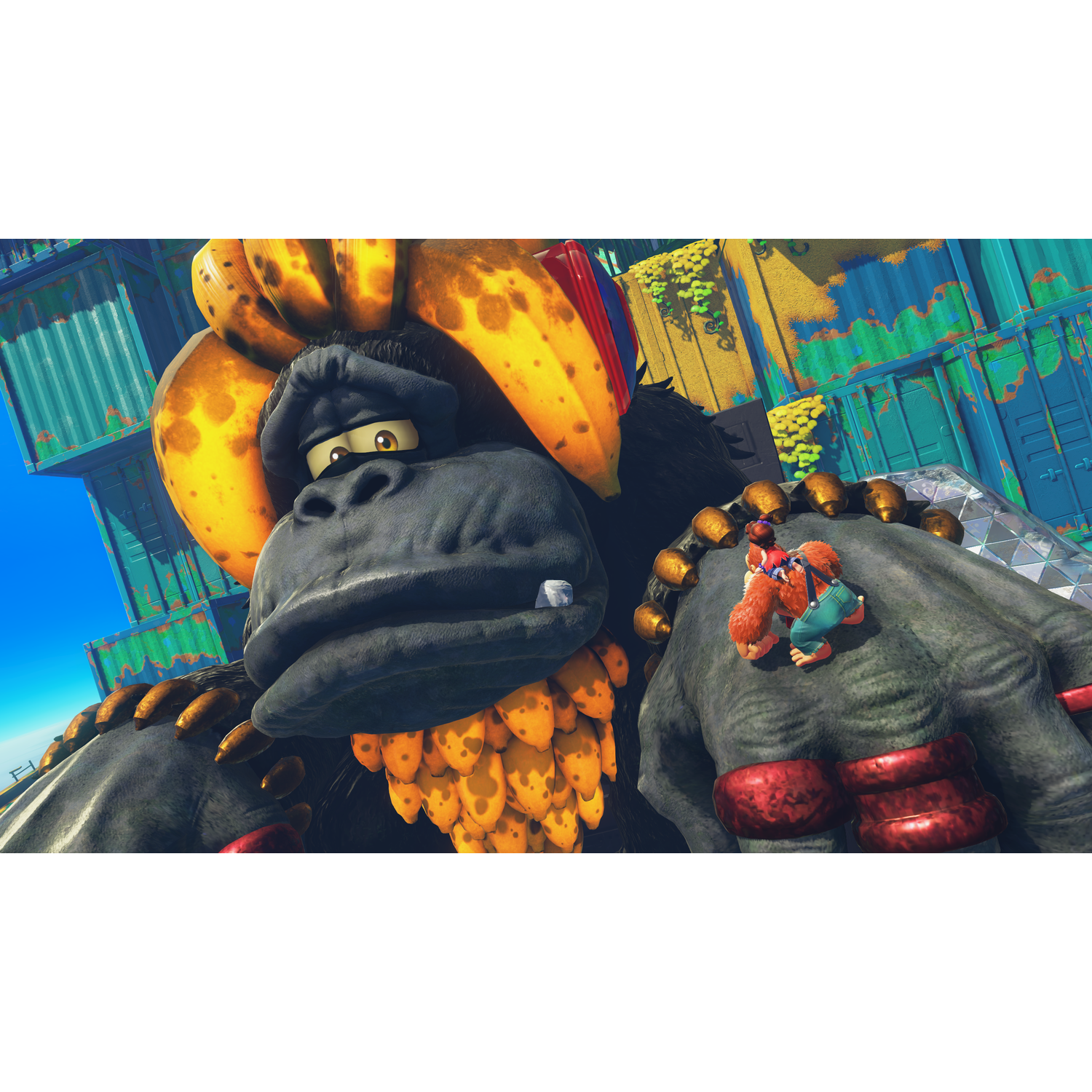 Donkey Kong with a banana crown holds a small, red-haired figure. Background has containers and blue sky.