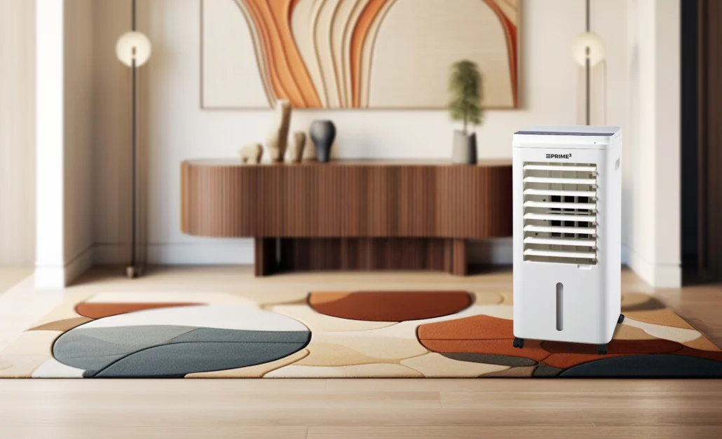 Biała chłodziarka powietrza stoi na wzorzystym dywanie w nowoczesnym salonie. Drewniana szafka i grafika w tle.