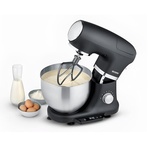 Czarny mikser stojący ze srebrną misą, mieszający ciasto. Obok składniki jak jajka, mąka i mleko.