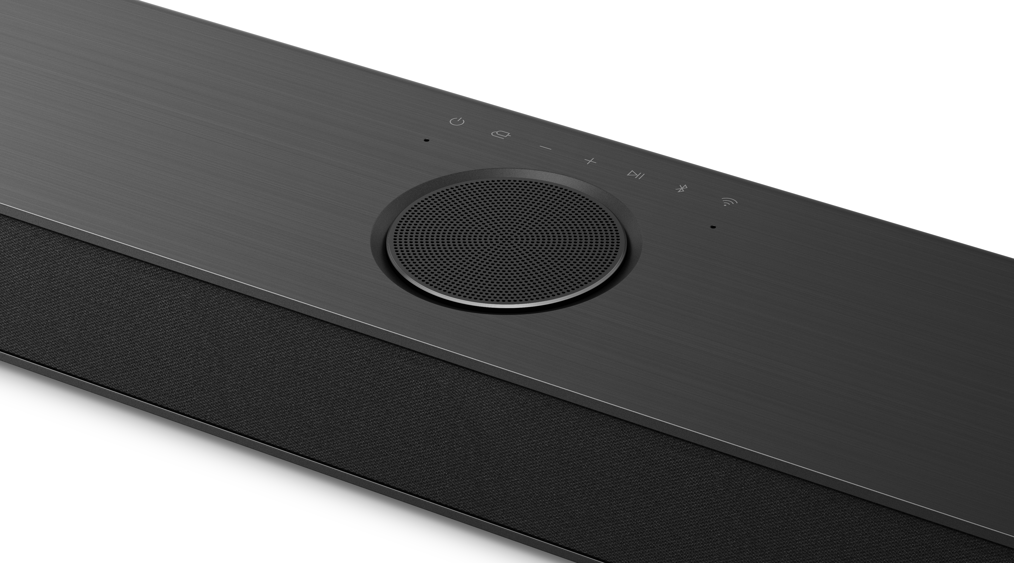 Eine schwarze Soundbar mit zentralem Lautsprecher, Bedienelementen und einem Mesh-Stoff-Panel darunter. Hintergrund ist weiß.
