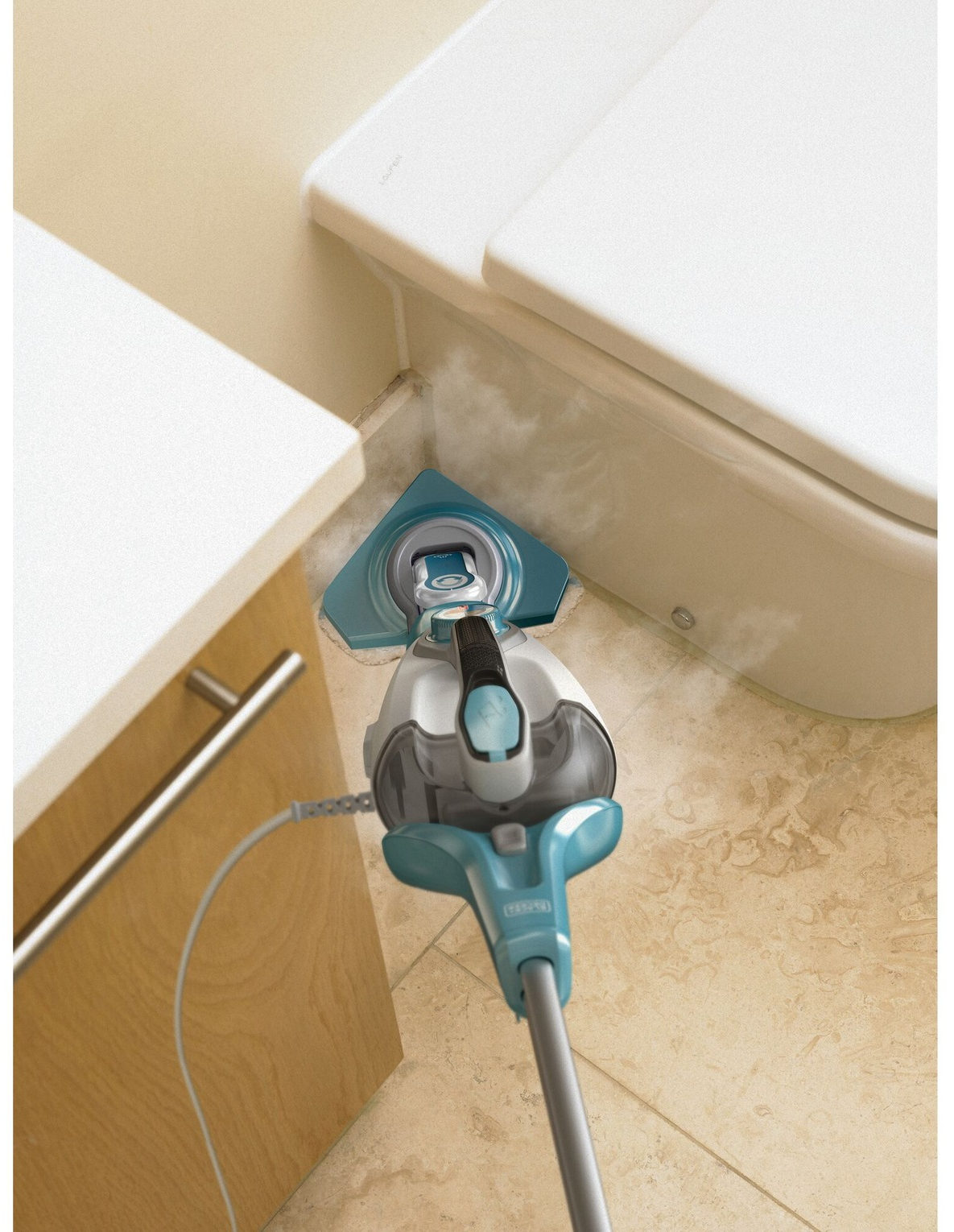 Un pulitore a vapore pulisce vicino a un water. Il pulitore è blu e bianco e il pavimento è piastrellato. Un mobile è a sinistra.