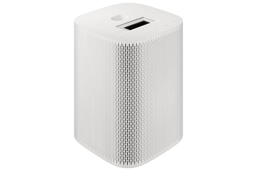 Un altavoz blanco y cilíndrico. Tiene una ranura rectangular y botones en la parte superior, con líneas verticales en los lados.