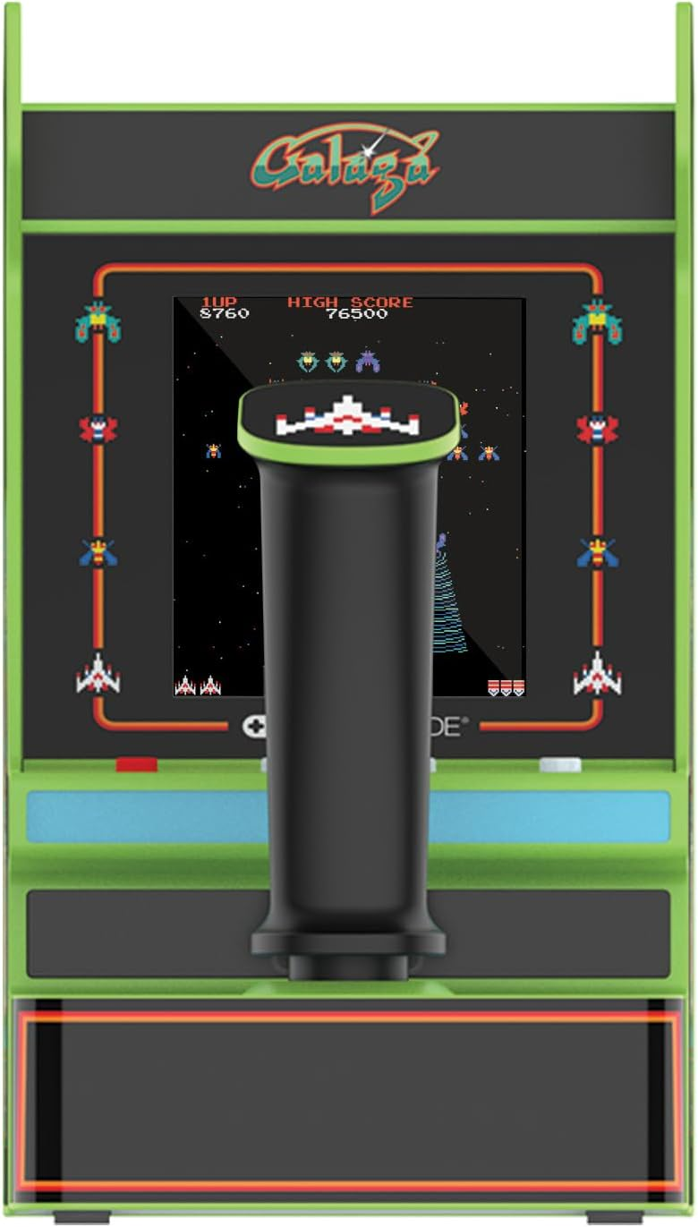 Una máquina arcade con el juego Galaga en la pantalla. Un joystick está en el centro. La cabina es verde y negra.