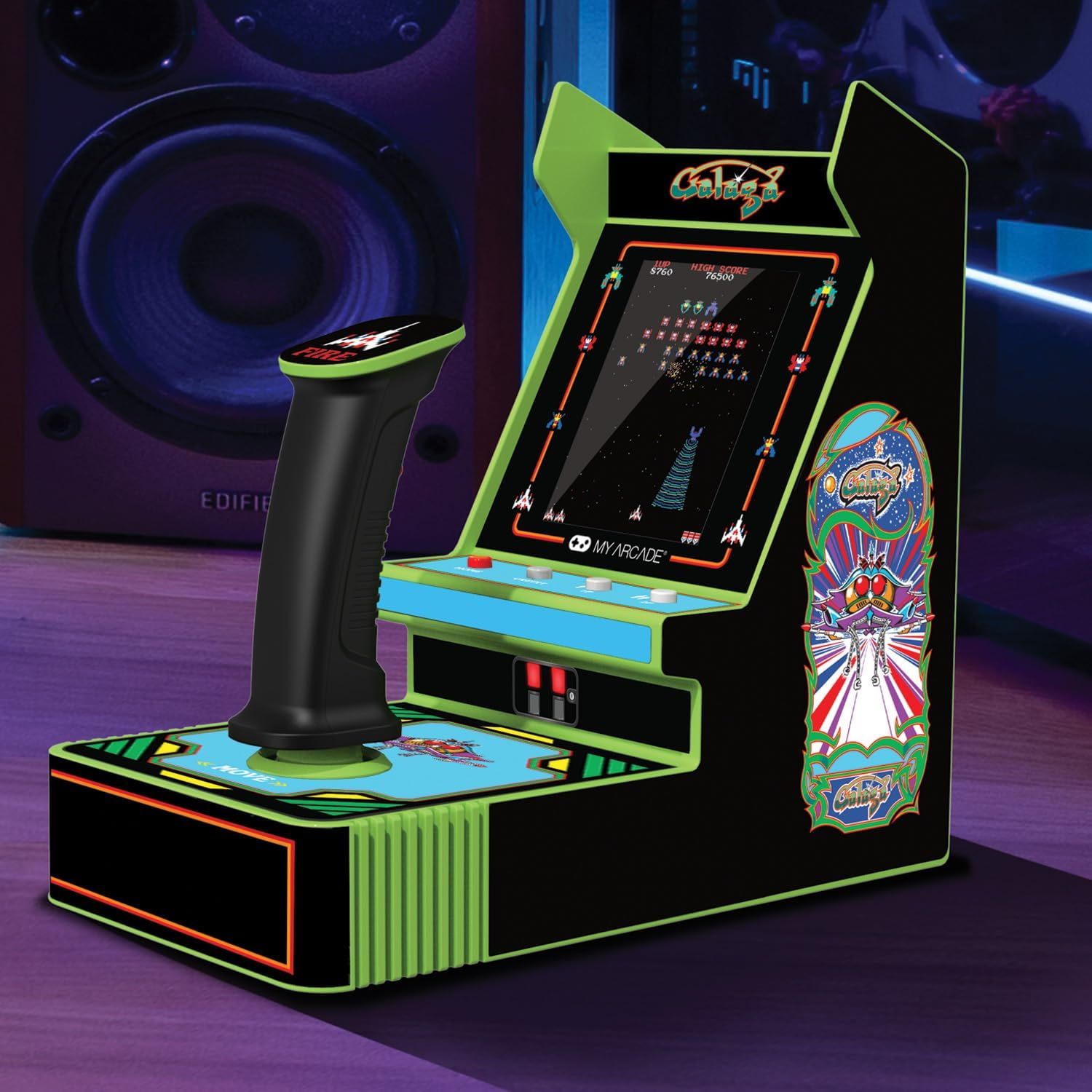 Una máquina recreativa con joystick. La pantalla muestra un juego de disparos espaciales. La máquina tiene una combinación de colores verde y negro.