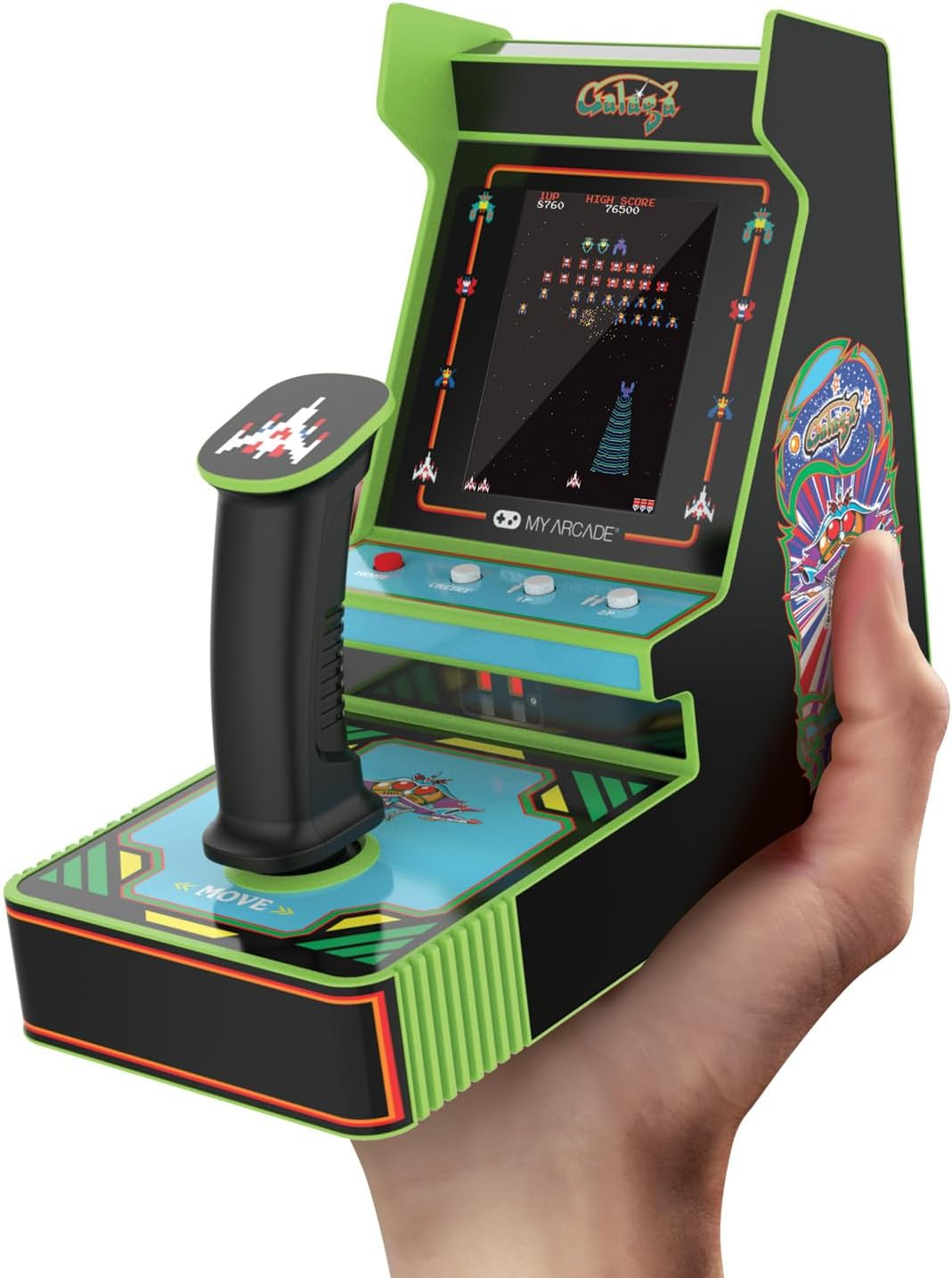 Una persona sostiene un minijuego de arcade. El juego es negro y verde, con un joystick. La pantalla muestra un juego de disparos espaciales.