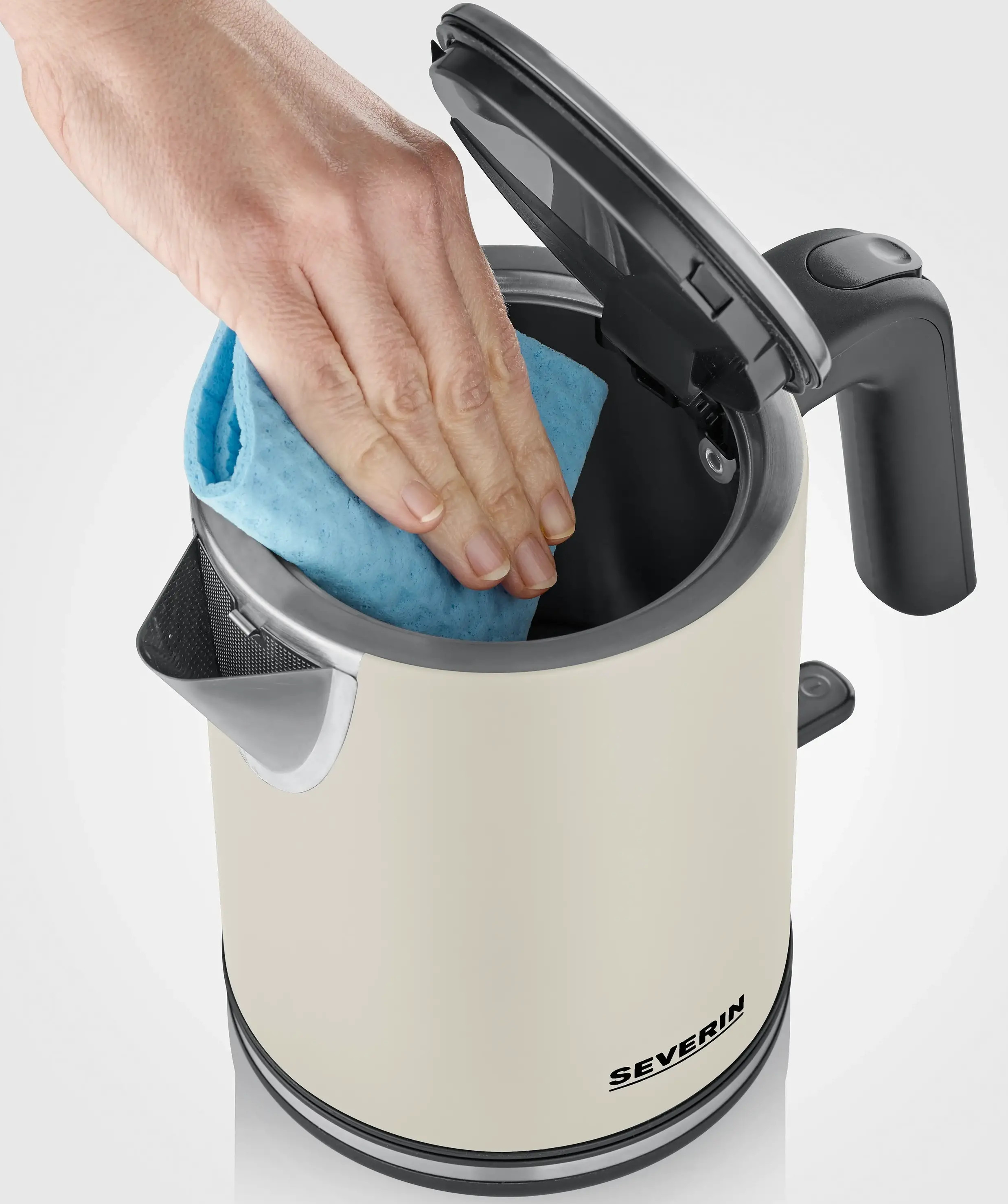 Ręka z niebieską gąbką czyści kremowy czajnik elektryczny. Pokrywka jest otwarta. Widoczna jest nazwa marki.