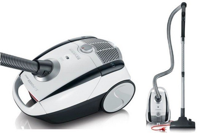 Dwa biało-czarne odkurzacze. Jeden z wężem, drugi bez. Widoczny czerwony przewód zasilający.