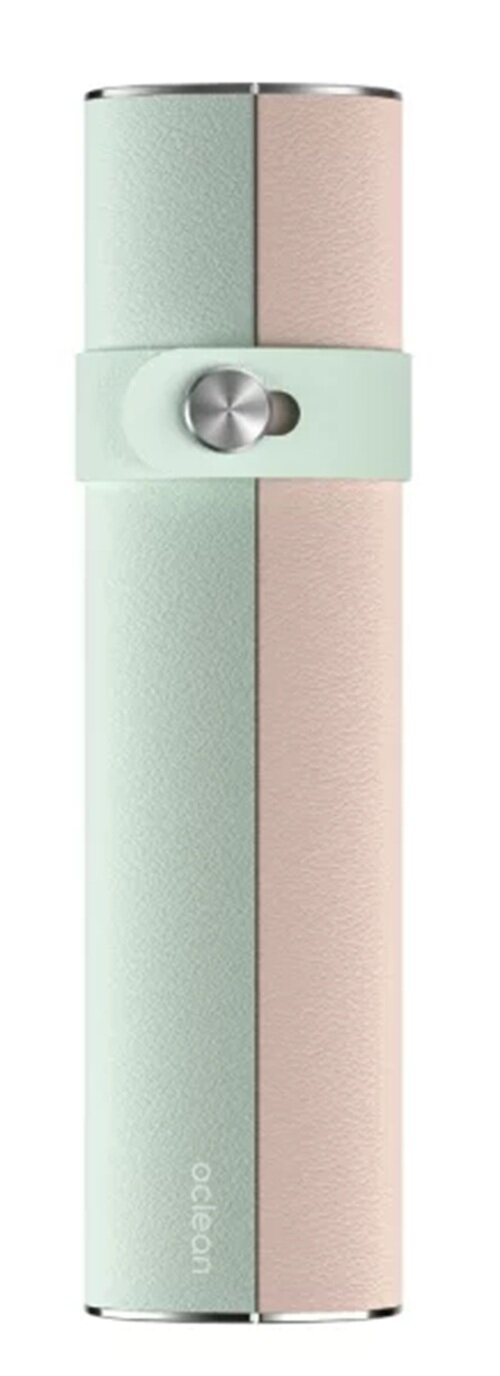 Podzielony cylindryczny przedmiot. Jedna połowa jest miętowo-zielona, ​​druga różowa. Pasek trzyma go razem ze srebrnym guzikiem.