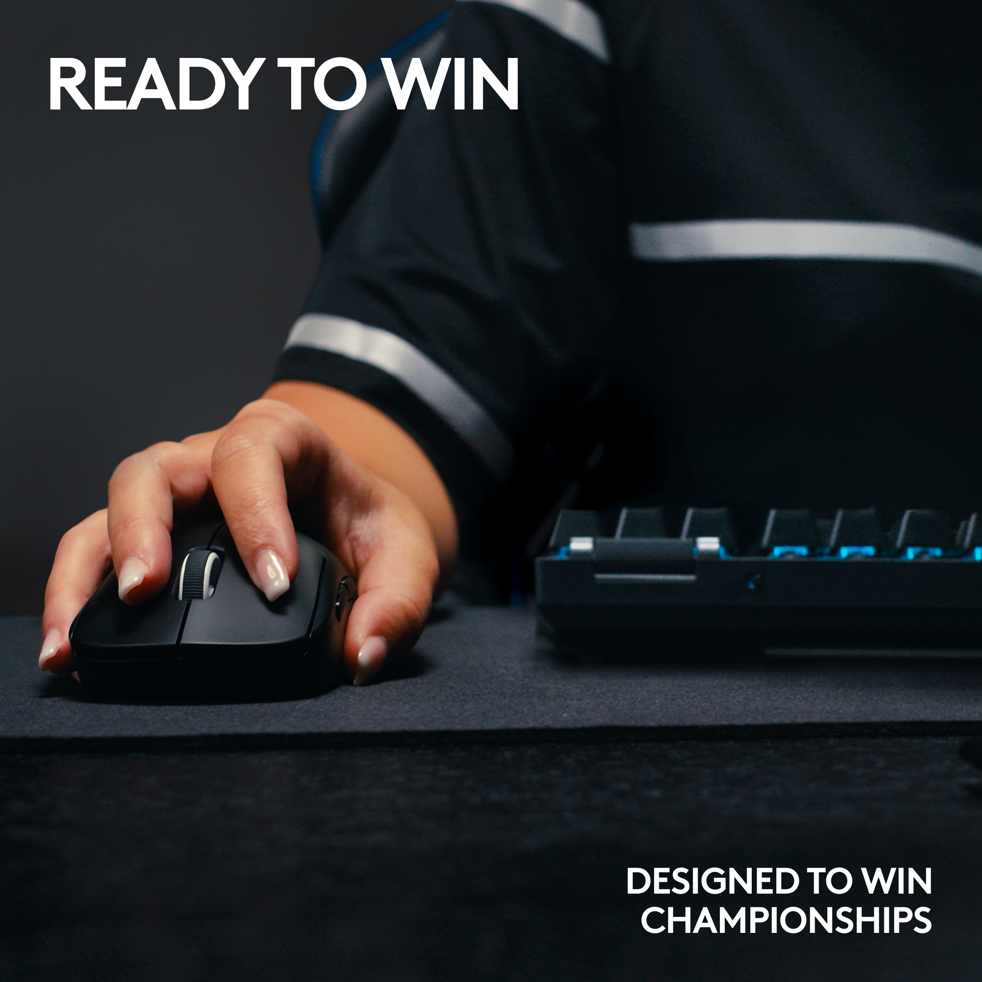 Hand benutzt schwarze Maus auf einer Matte. Tastatur im Hintergrund. Text: 'Ready to Win' und 'Designed to Win Championships'.