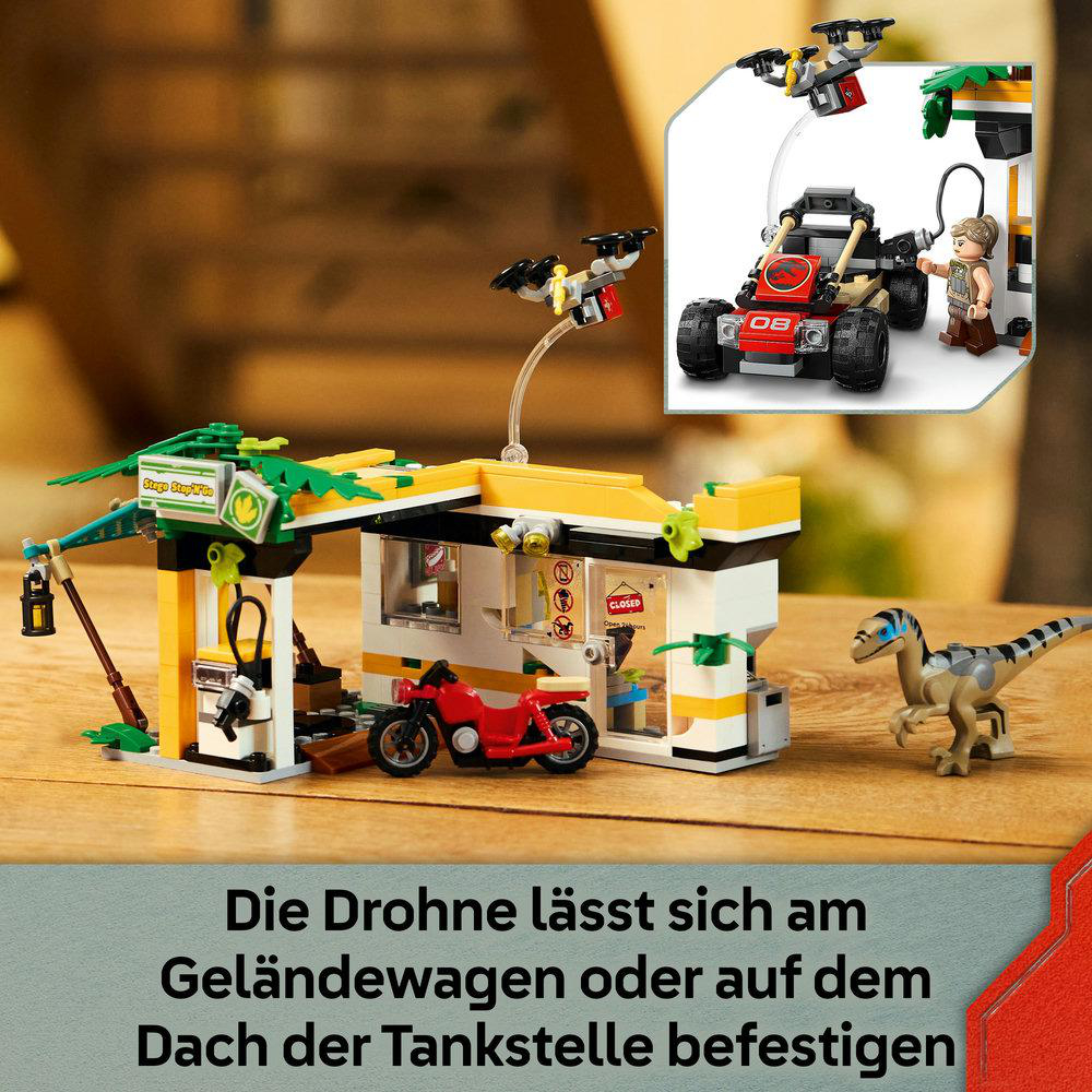Eine Spielzeug-Tankstellenszene mit Motorrad, Drohne, Auto und Dinosaurierfiguren. Die Station ist gelb und weiß.