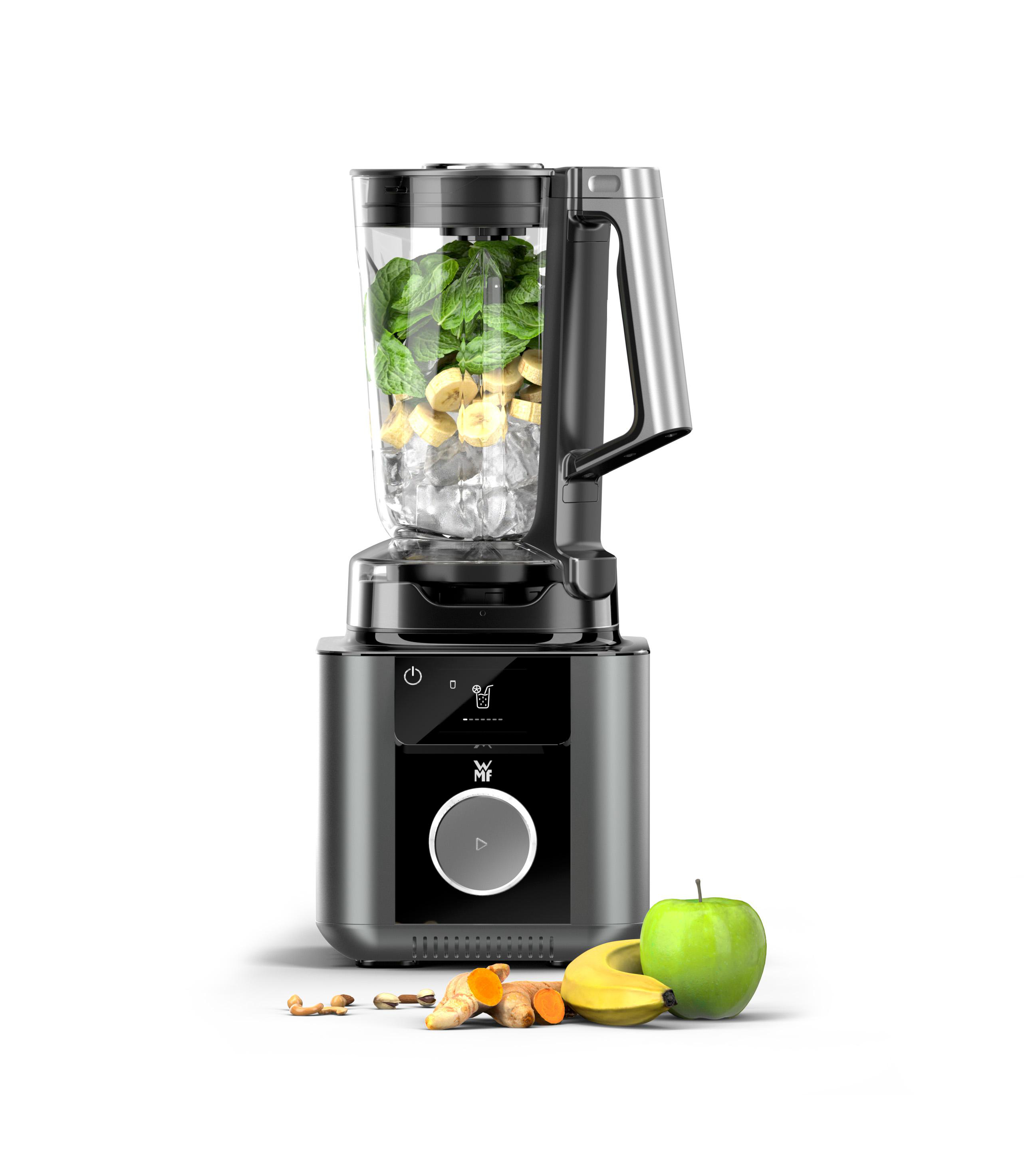 Mixer mit Zutaten: Spinat, Bananen, Eis. Apfel, Banane, Kurkuma, Nüsse an der Seite. Weißer Hintergrund.